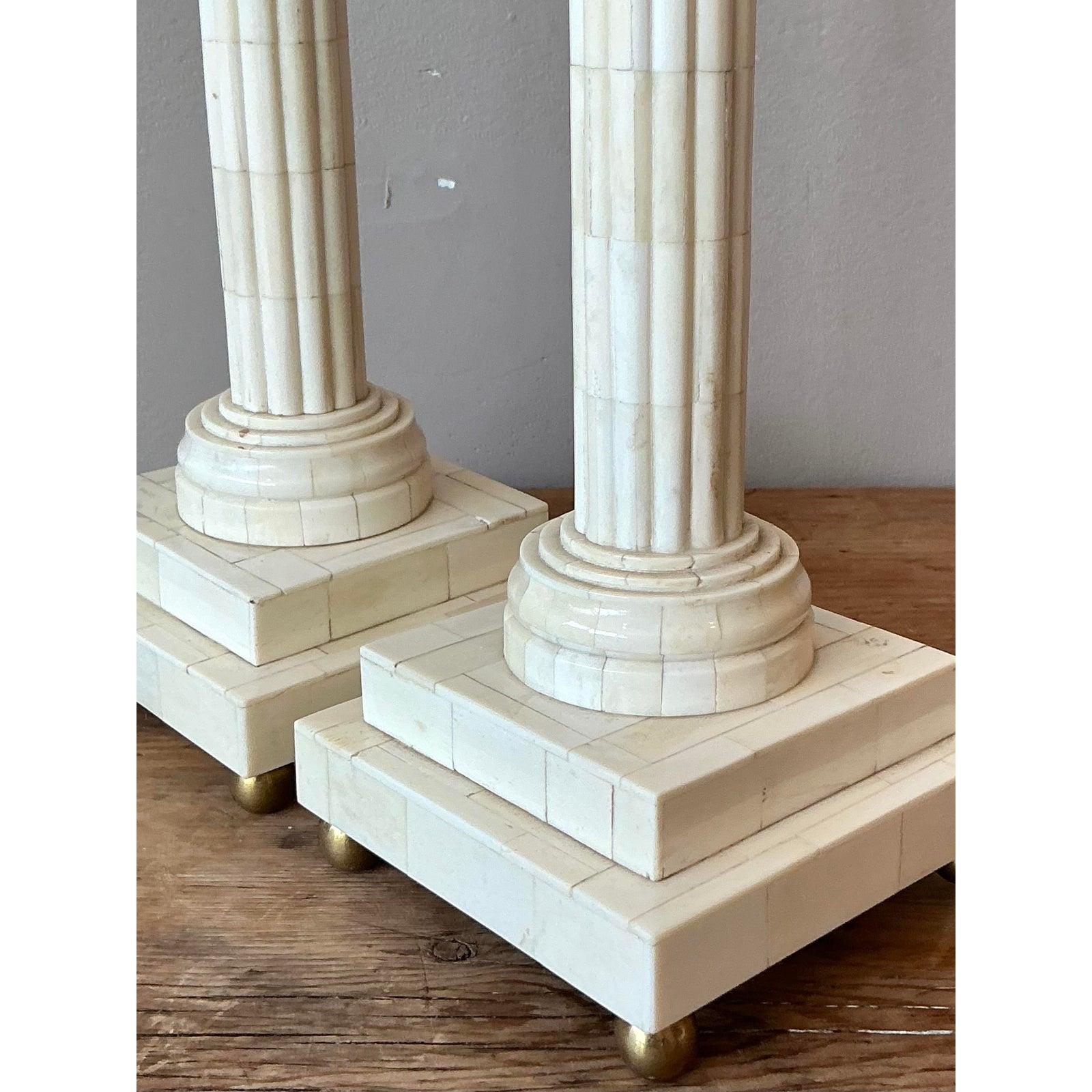 Ti presentiamo una splendida coppia di candelieri vintage neoclassici in osso tassellato, progettati per infondere alla tua casa un'aria di eleganza classica e fascino storico. Ogni candeliere presenta una colonna scanalata, meticolosamente