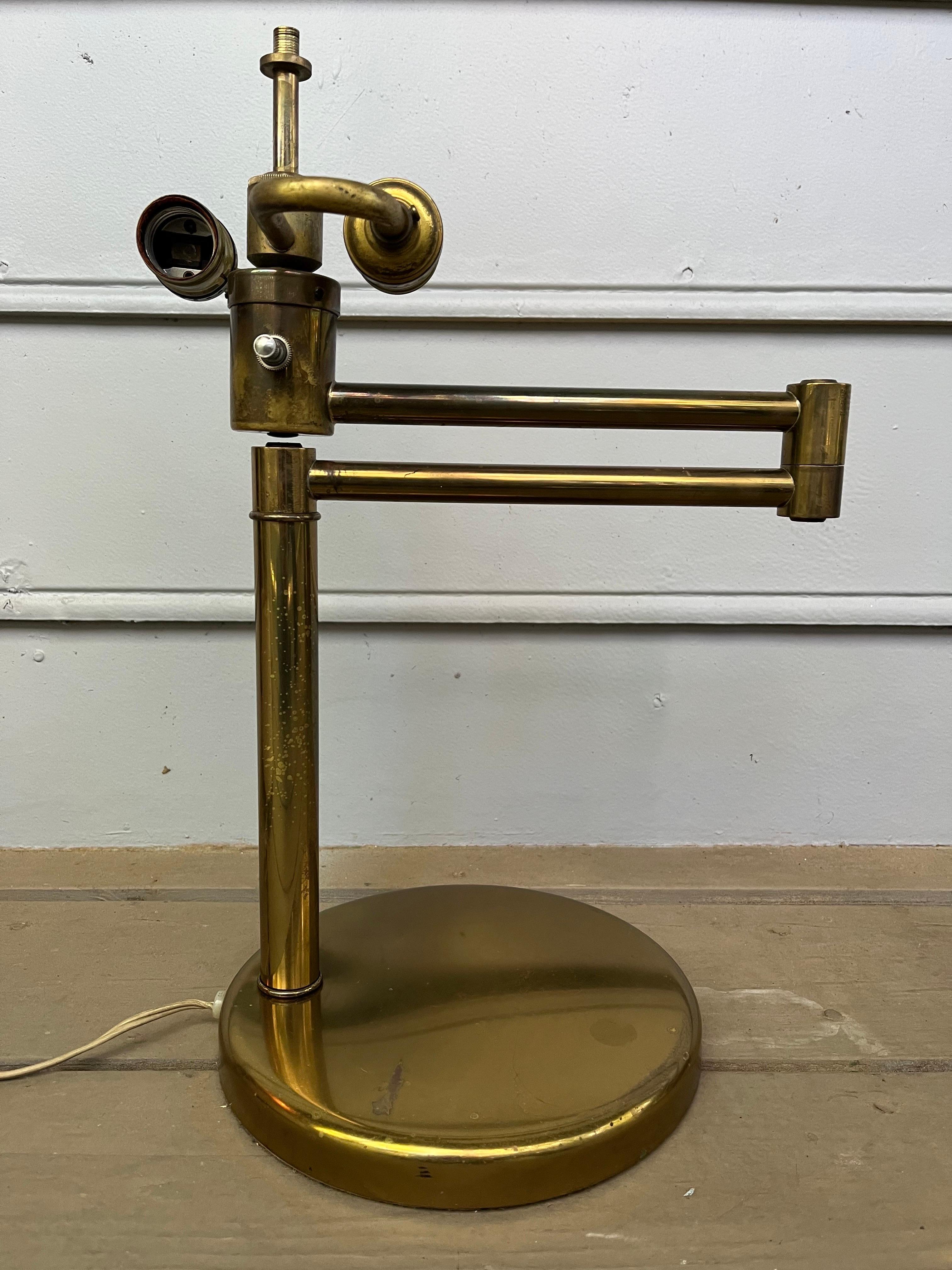A vintage, mid century modern table or task lamp designed by Walter Von Nessen in the 1930's and produced in New York City sometime in the 1950's or 1960's by Nessen Lighting. This is the brass version with linen shade and white painted metal