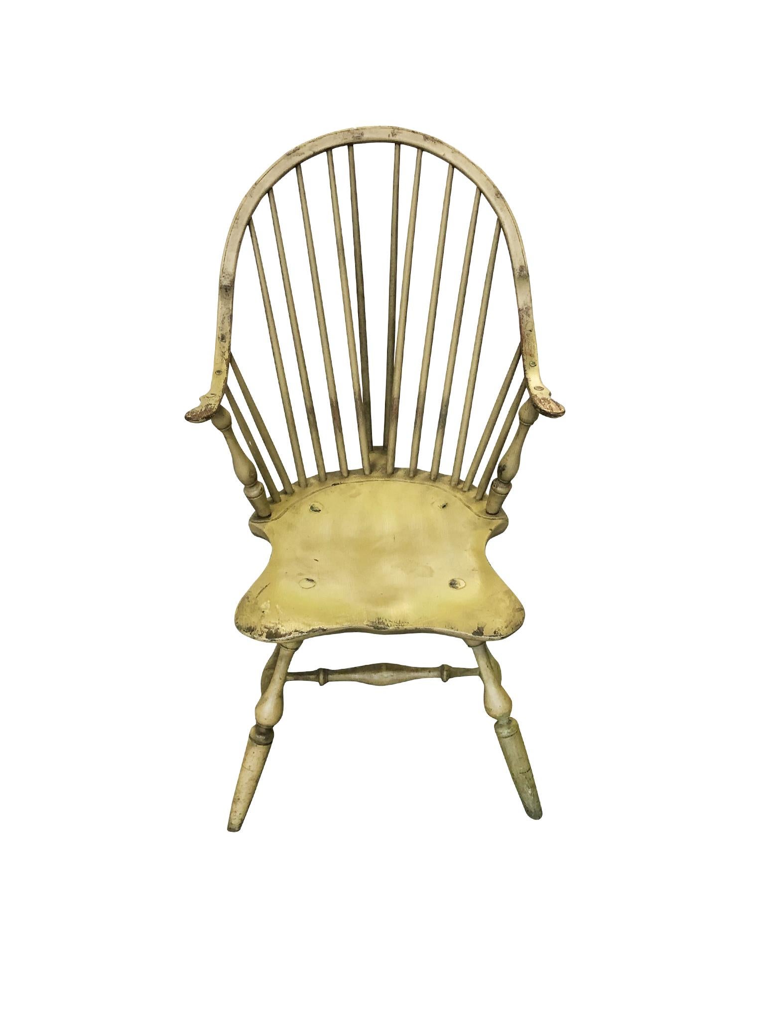 A Windsor chair handcrafted from poplar wood by Bill Wallick. Hand painted in a pale olive-yellow finish. 1980s-1990s. The chair's design is a Classic Windsor shape consisting of a spindle back with a tail piece, and a steam-bent arched crest