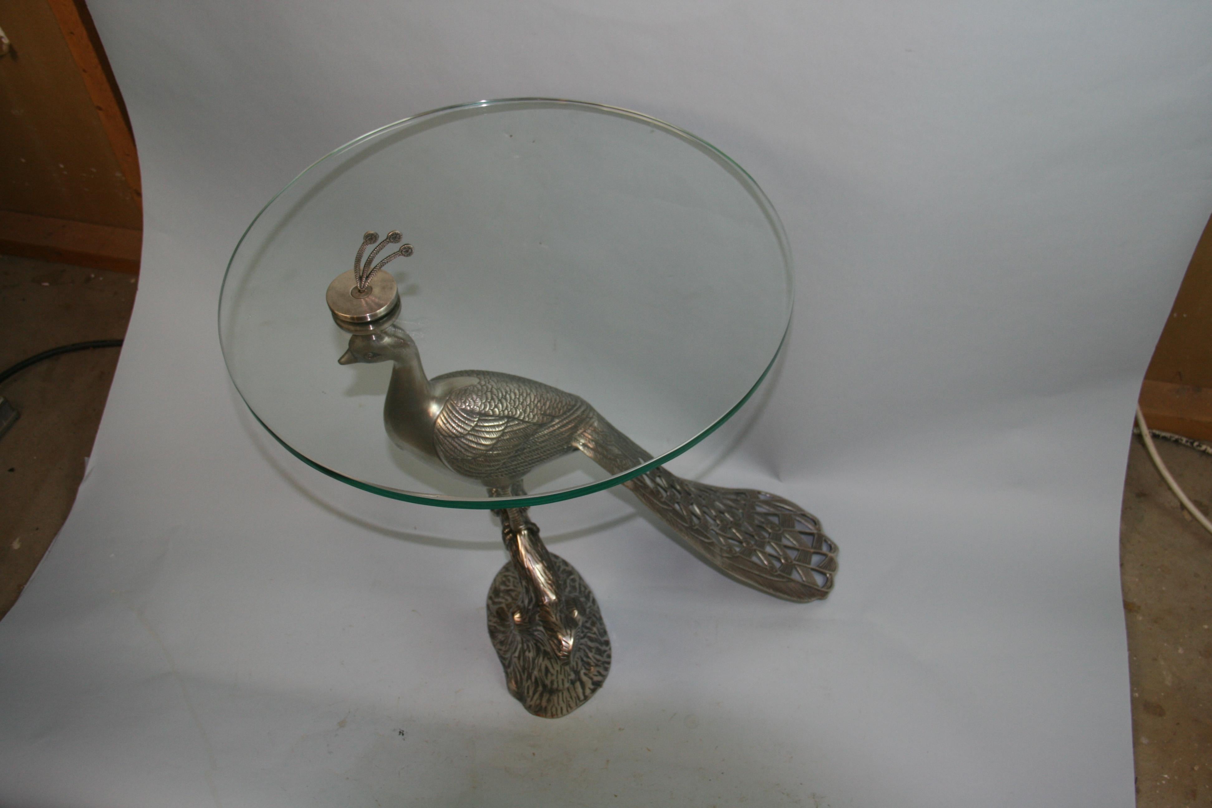 1276 Well detailed Hollywood Regency nickel plated brass peacock table with glass top.
The charming vintage peacock table is the perfect side table,drink table,or gueridon.