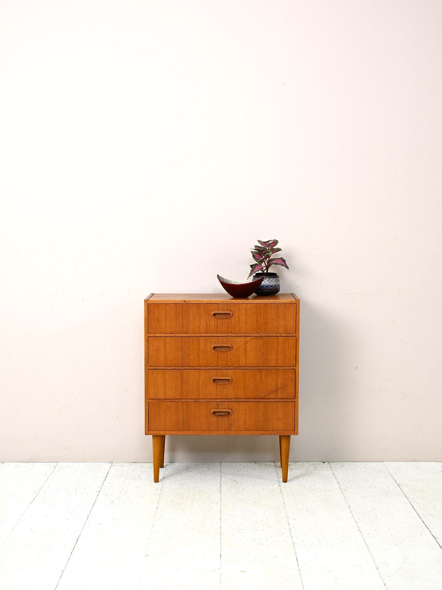 Scandinavian 1960s teak cabinet.

This original midcentury piece of furniture can be used as a nightstand or as an entryway cabinet due to its small size. 
It is characterized by its simple, square lines as opposed to the soft shapes of the