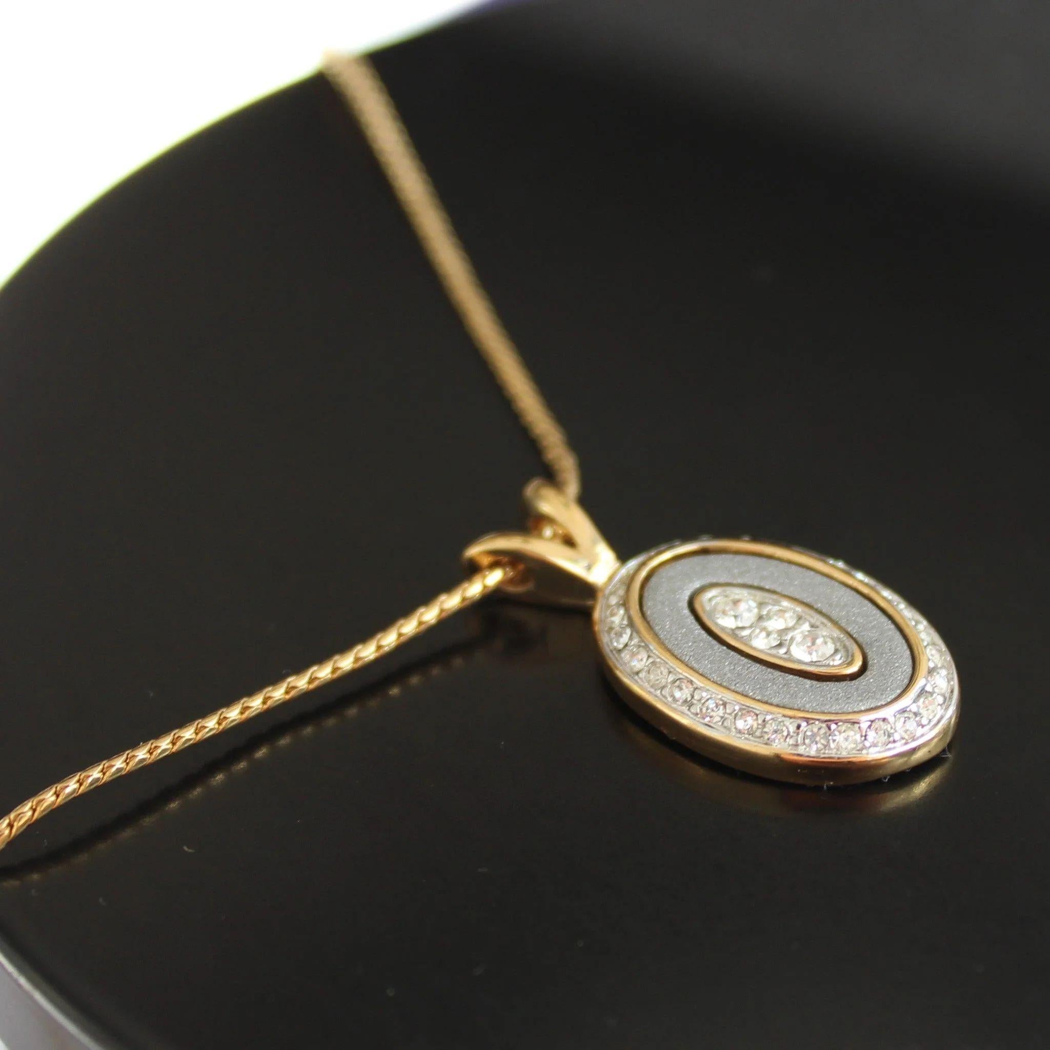 Add a touch of vintage elegance to your jewellery collection with this stunning Vintage Nina Ricci 1980s Pendant Necklace. Delicate and dainty, this necklace features a small oval pendant set with tiny crystals, all housed in a beautiful gold-plated