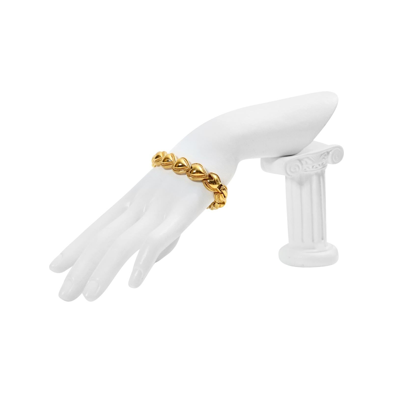 Vintage Nina Ricci Gold Links of Heart Bracelet, Circa 1980s. Les cœurs sont reliés les uns aux autres et un motif est gravé tout autour. Il s'agit d'un bracelet robuste et de bonne facture. Il serait parfait superposé à d'autres ou porté avec une
