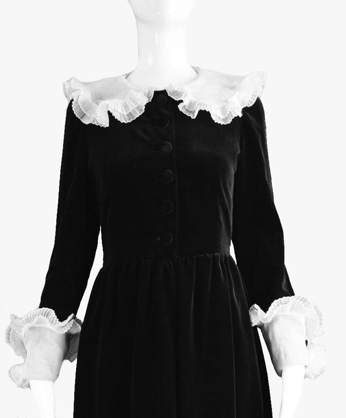 Ein exquisites Vintage Demi Couture Abendkleid aus den 1980er Jahren von  Nina Ricci.

Wunderschön konstruiert mit vielen Details, von Hand verarbeitet, in einem prächtigen schwarzen Samt mit weißem plissiertem Organzakragen und passender