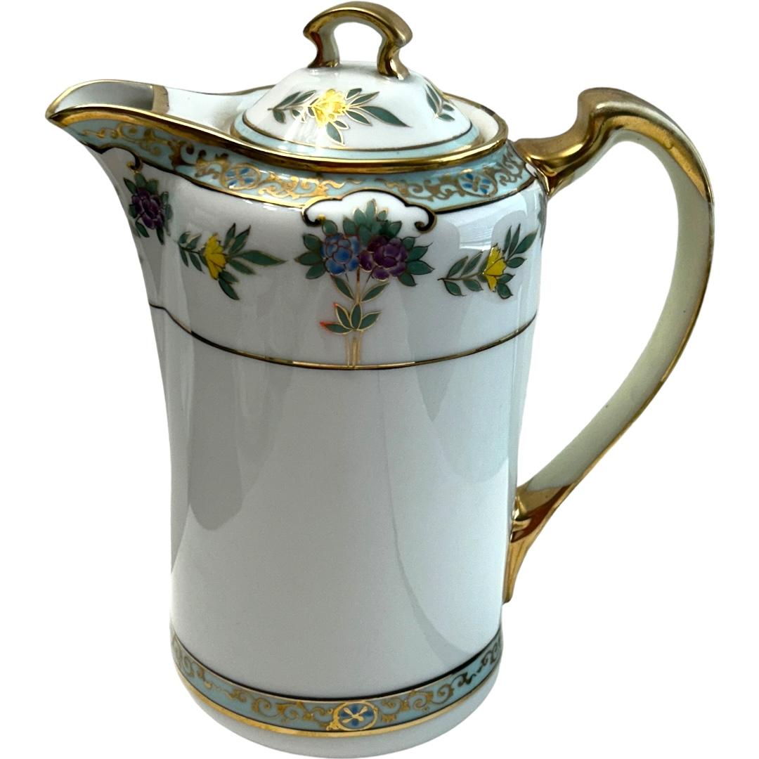 This vintage Nippon tea/coffee pot set is a stunning addition to any collection.  The hand-painted floral design showcases the intricate detail and skilled craftsmanship of the porcelain material. The set includes a beautiful coffee pot and 6