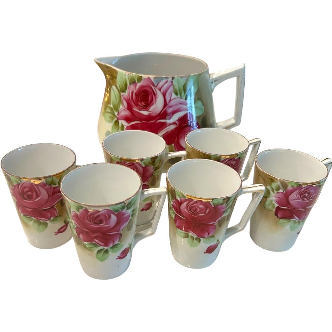 This vintage 7-piece set from Japan showcases intricate floral hand-painted designs.  The teapot and six matching cups are perfect for enjoying lemonade or iced tea.  The set is a beautiful representation of Japanese culture and craftsmanship, with