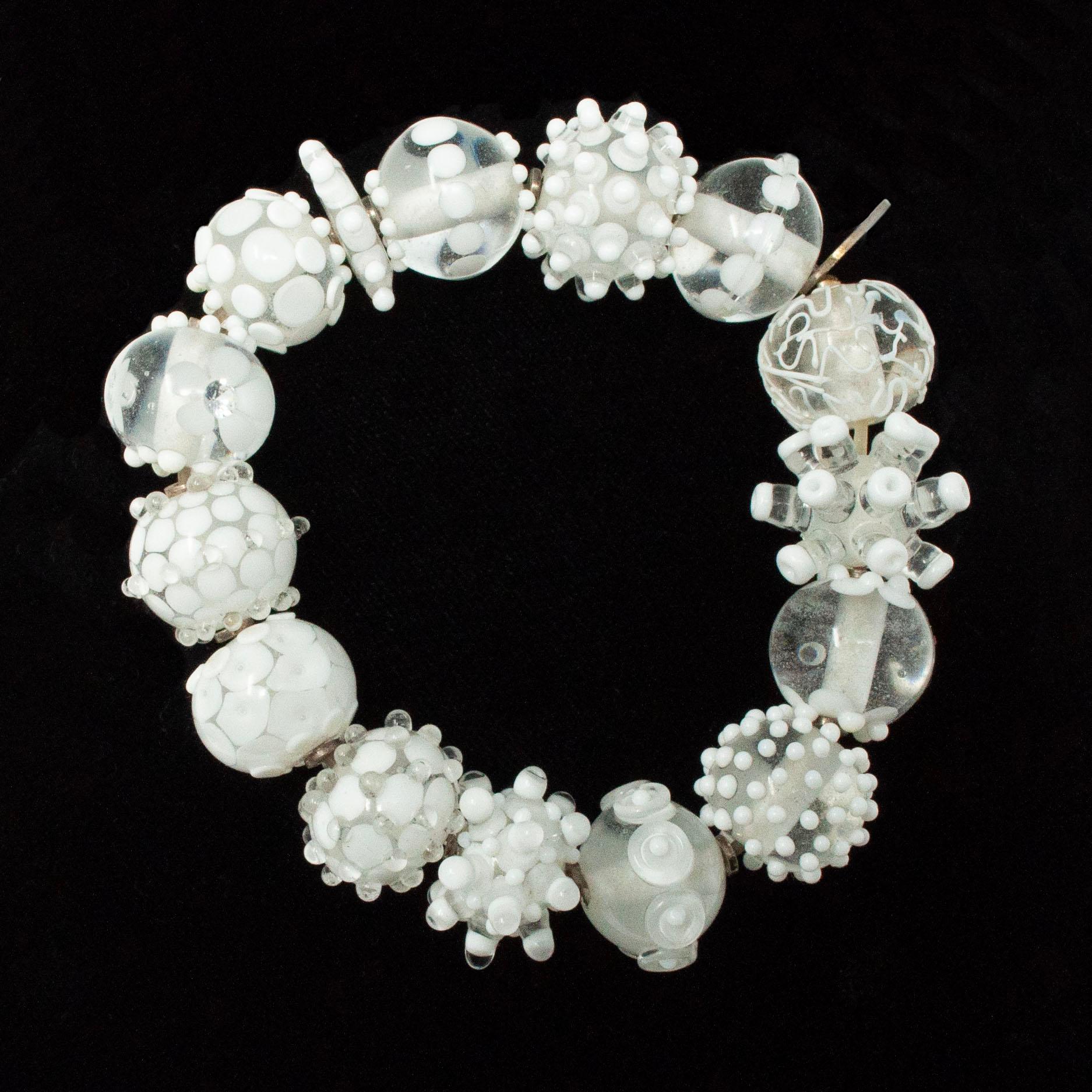 Vintage Nirit Dekel White Handmade Glass Bead Bracelet

This beautiful white lampwork beaded bracelet was created by Israeli glass artist Nirit Dekel, who was inspired by a Chihuly exhibit in Jerusalem in 2000 and has been creating artful beaded