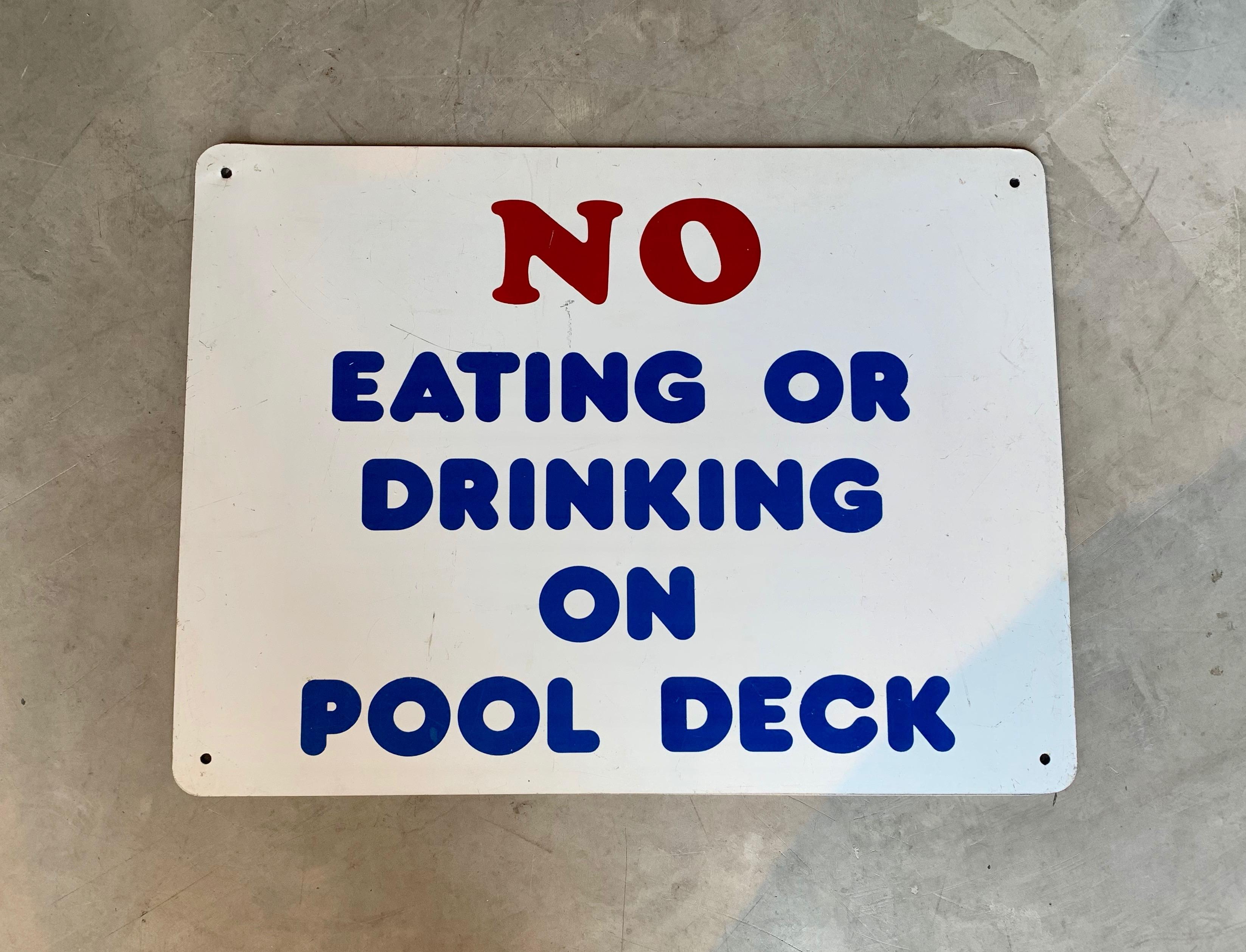 Vintage metal sign from a public pool. White sign with red and blue lettering. No eating or drinking on pool deck. Good condition with some scratches.
