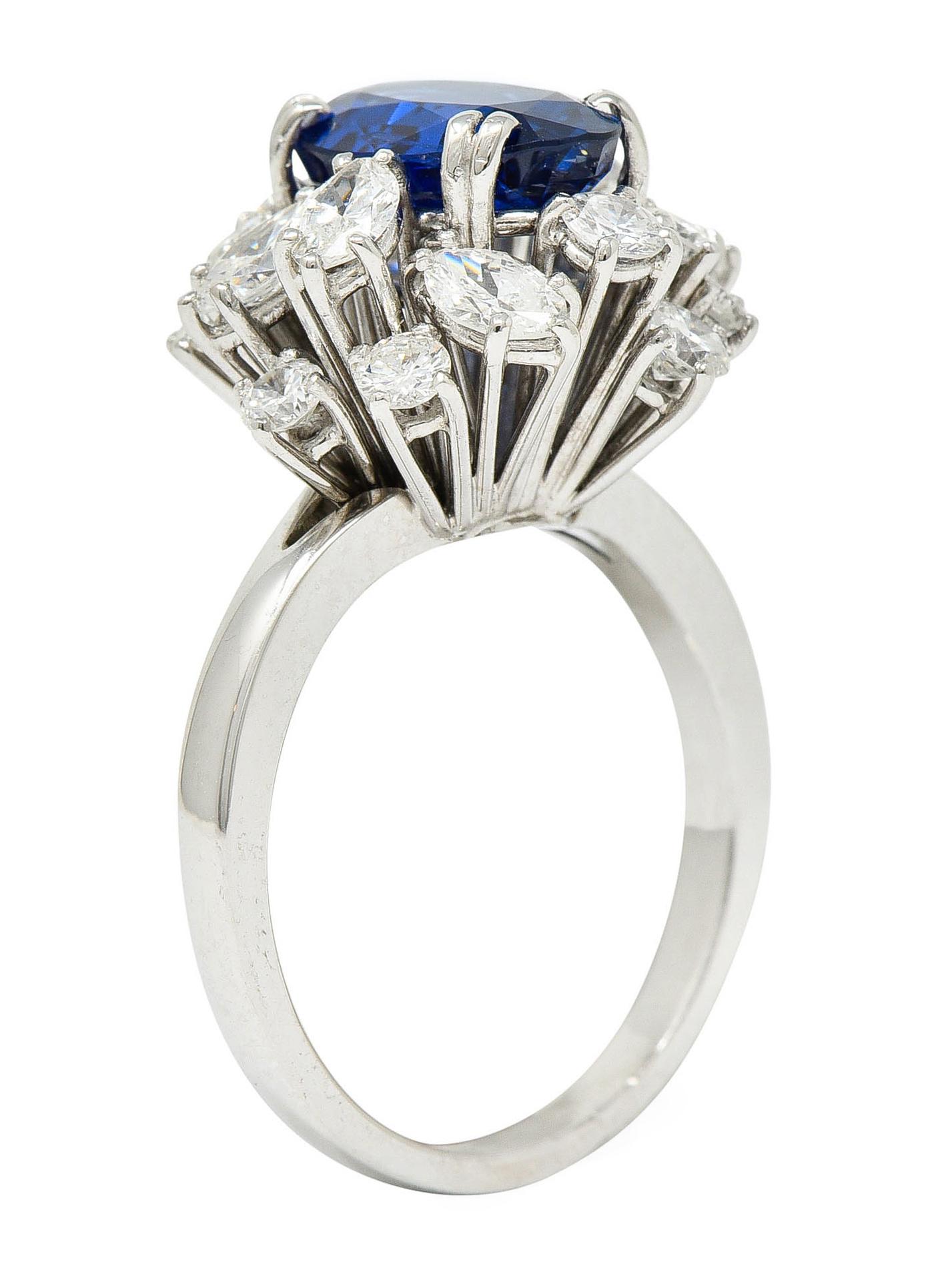 Cluster ring centers an oval mixed cut Burma sapphire weighing 2.61 carats

Bright royal blue in color with no indications of heat

Set by split prongs and surrounded by a cluster of marquise and round brilliant cut diamonds

Weighing in total