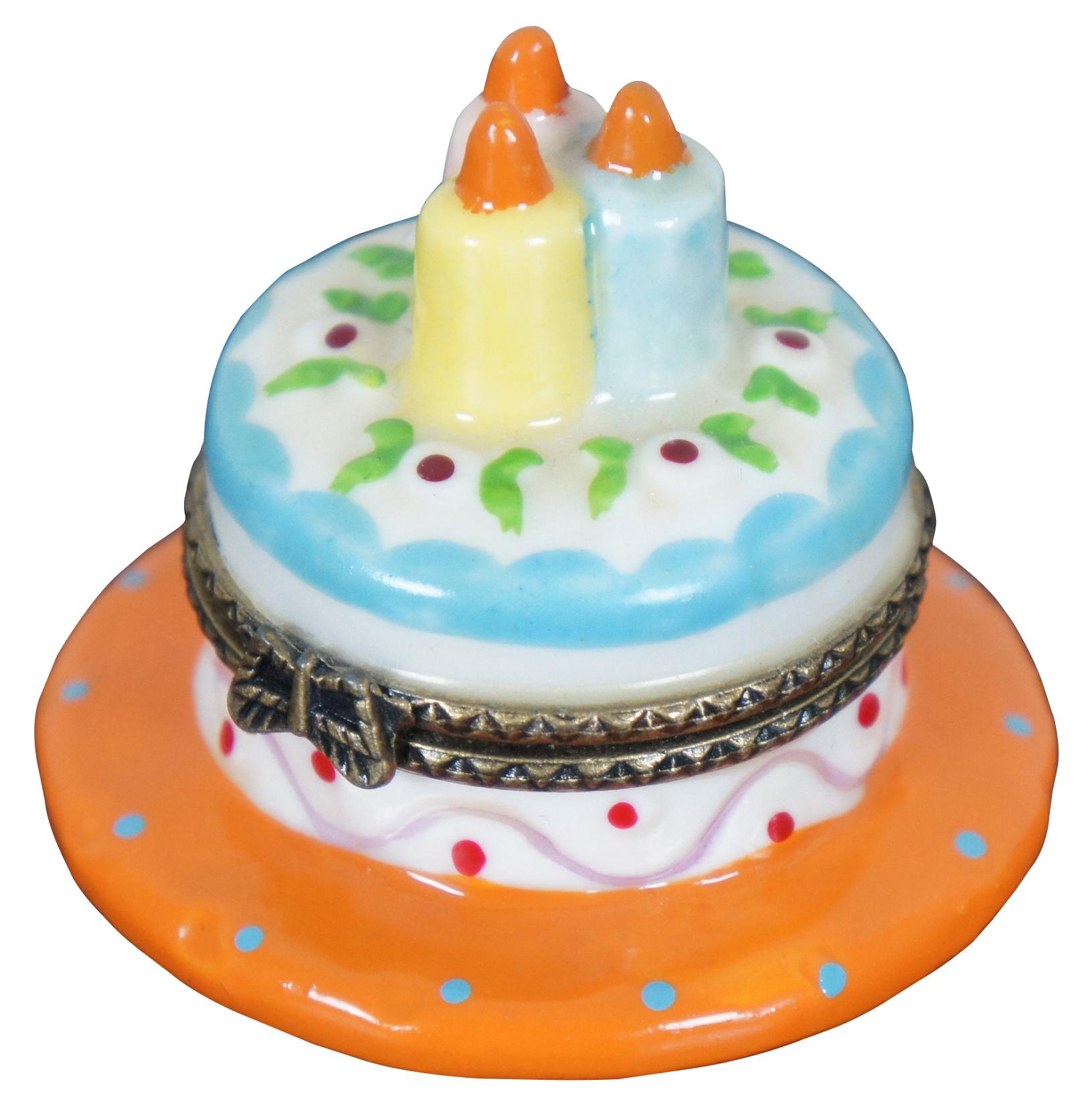 Vintage Nomoges porcelain trinket or pill box shapes like a blue and white birthday cake on an orange plate with three candles.