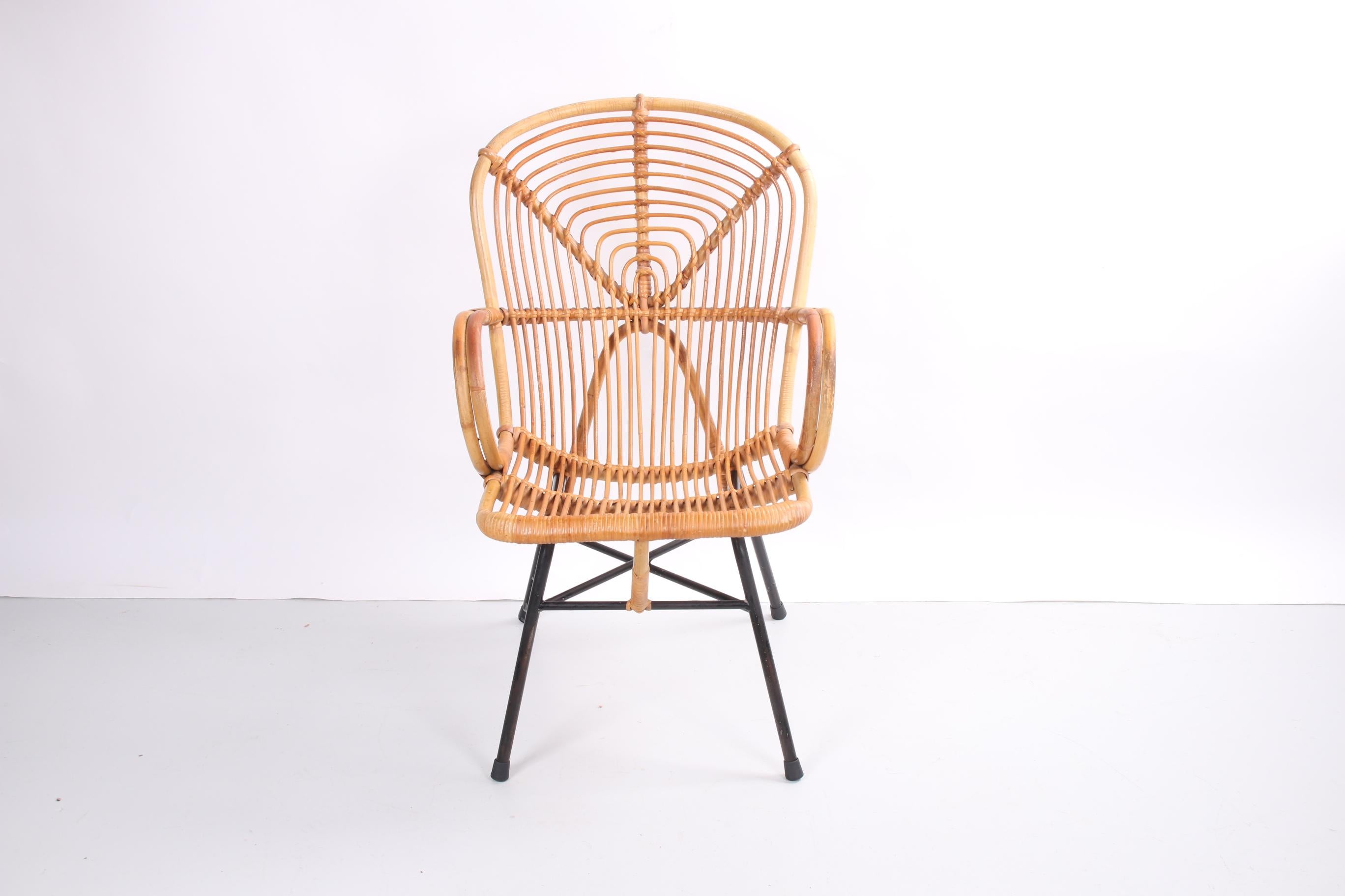 This beautiful bamboo lounge chair from Noordwolde fits perfectly into any interior. The chair was probably produced around the 1950s.

The black metal base gives the chair something cool and minimalist. Yet the chair with its hand-woven bamboo seat