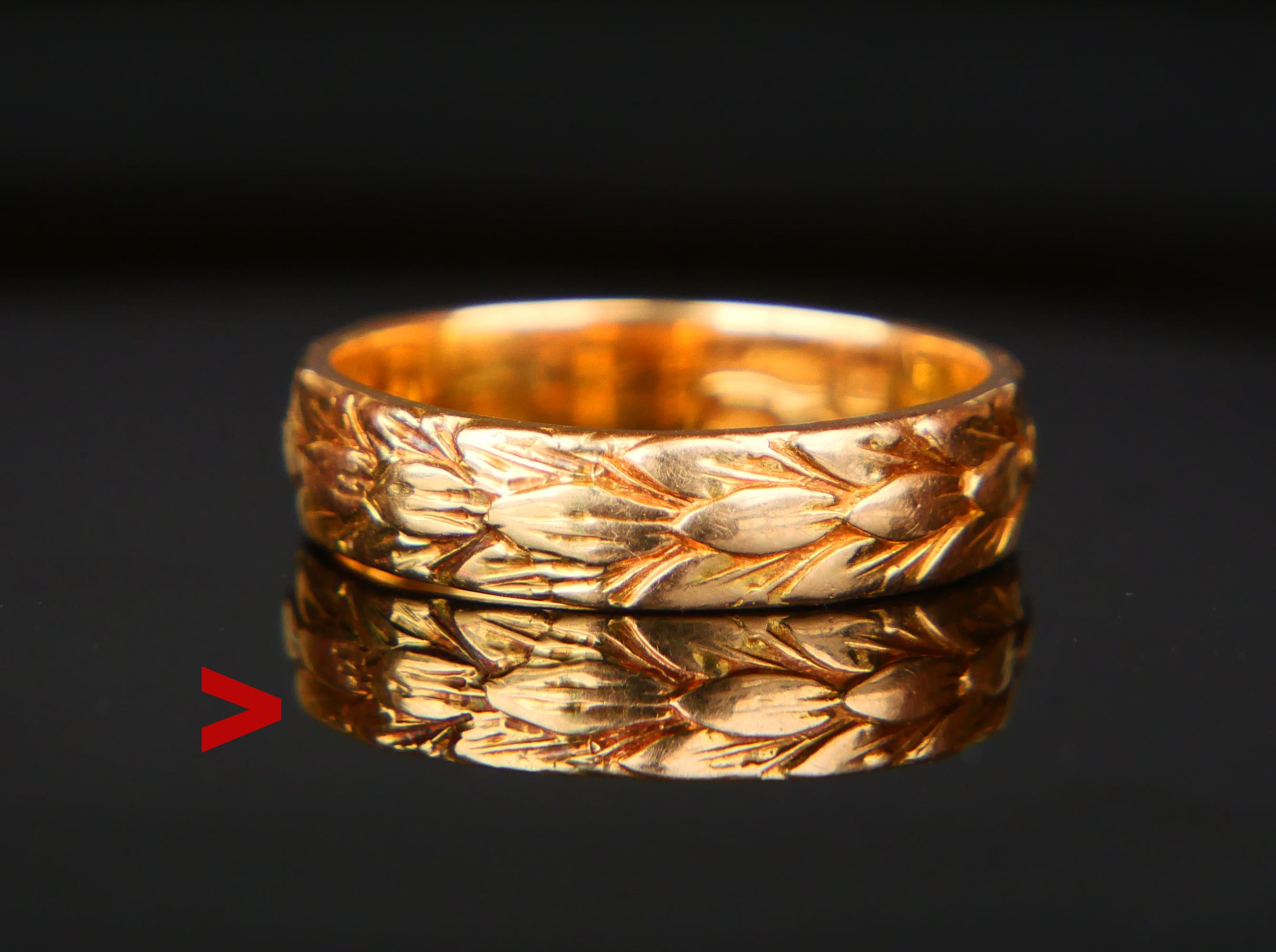 Anillo para hombre o mujer de oro amarillo macizo de 18 quilates con decoración continua de hojas de laurel fundidas. La banda mide 5,5 mm de ancho.

Este anillo tiene un juego de sellos suecos,18K, ciudad de Umeå, del fabricante y código de fecha