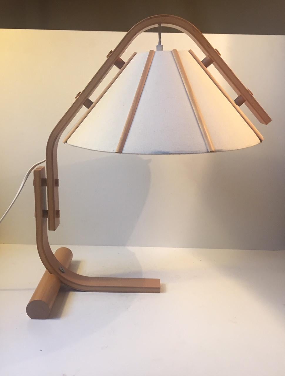 A Nordic modern styled table light made from bend wood beech and linen. Designed by Jan Wickelgren for Aneta in Sweden during the 1970s. The base is labeled with designer attribution and makers mark.