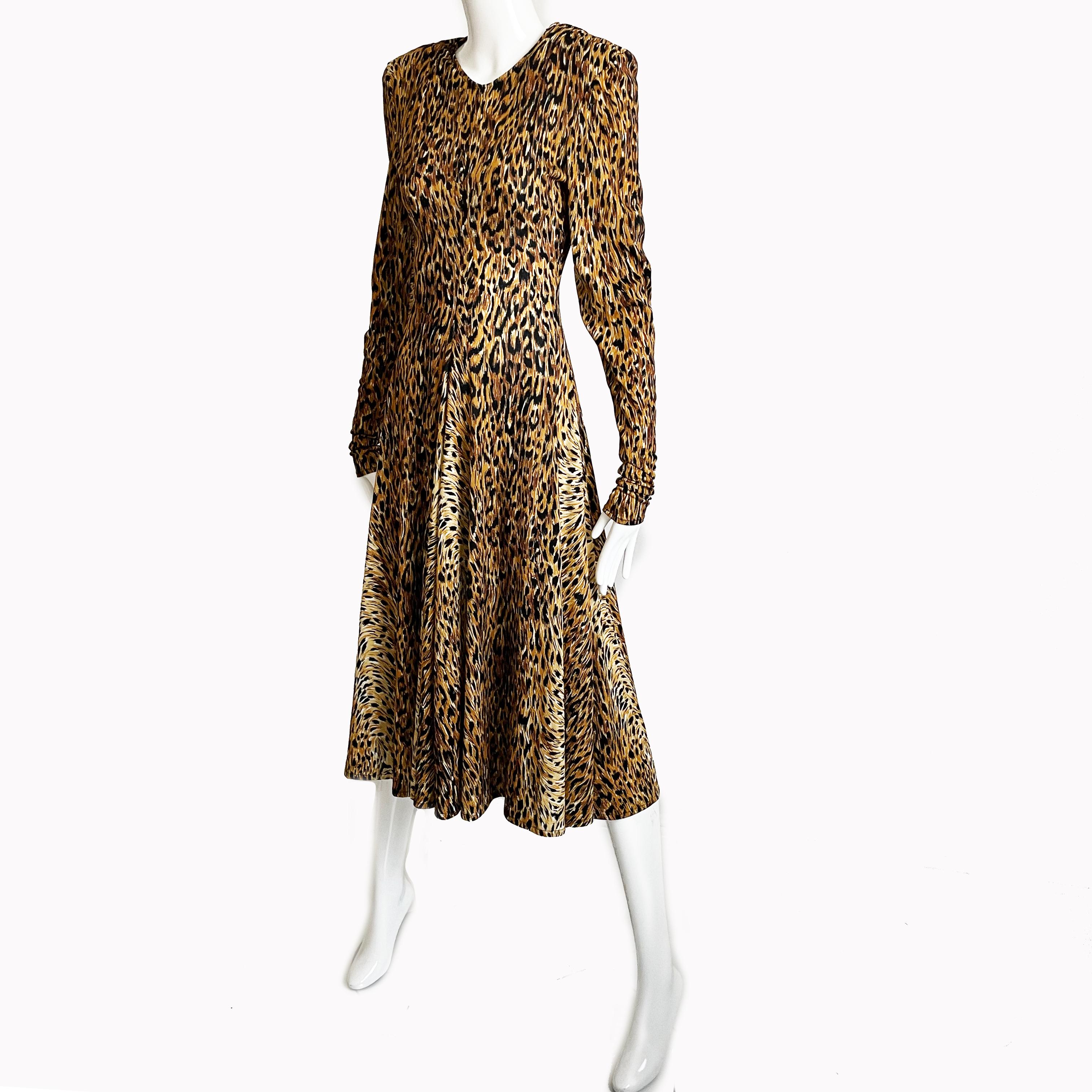 Authentic, preowned, vintage Norma Kamali leopard print dress with wide circle skirt, circa the 80s. Made from lightweight jersey fabric. Unlined/removable shoulder pads/slips over head. No content label, feels synthetic. Hand wash only. 