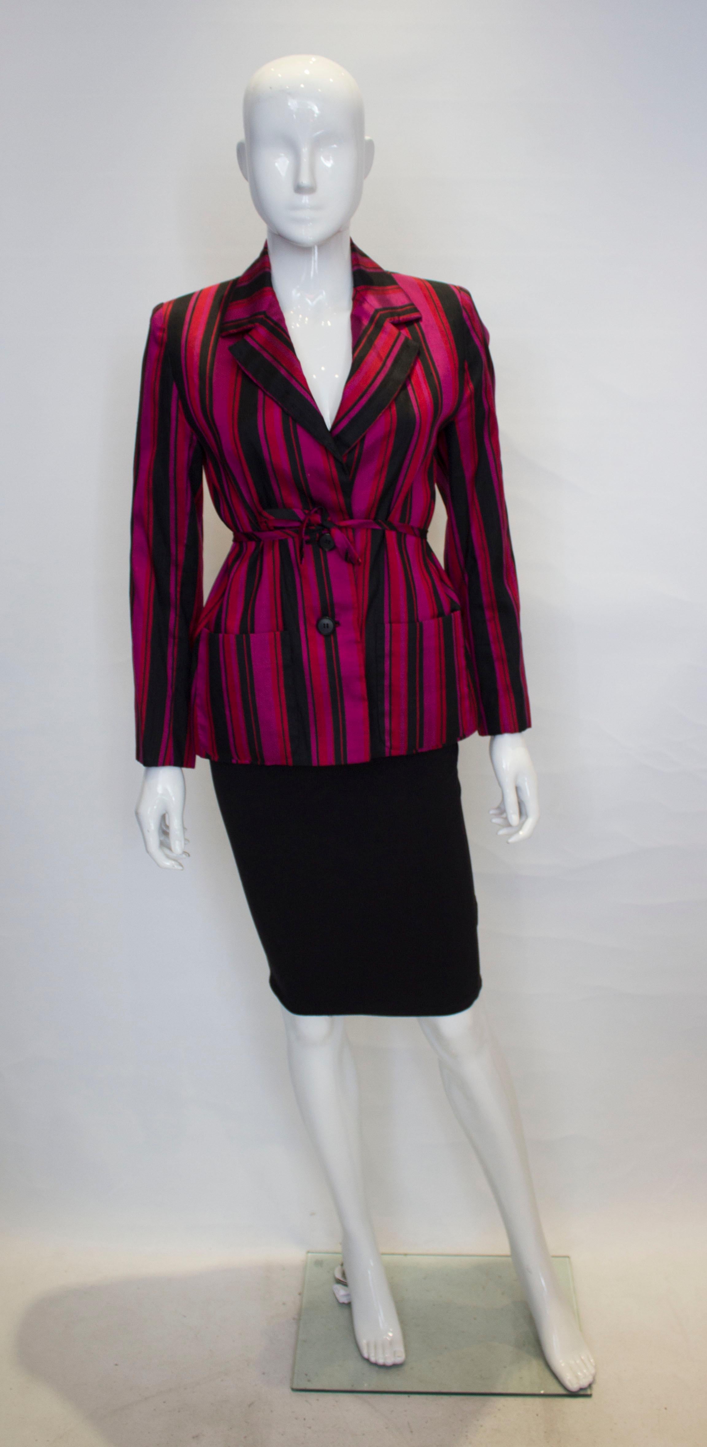 A stunning silk vintage jacket by Norman Hartnell, Le petit salon line.
The jacket is in a wonderful colour clash of red, pink and black. It has a two button front opening with two front pockets and is fully lined. 