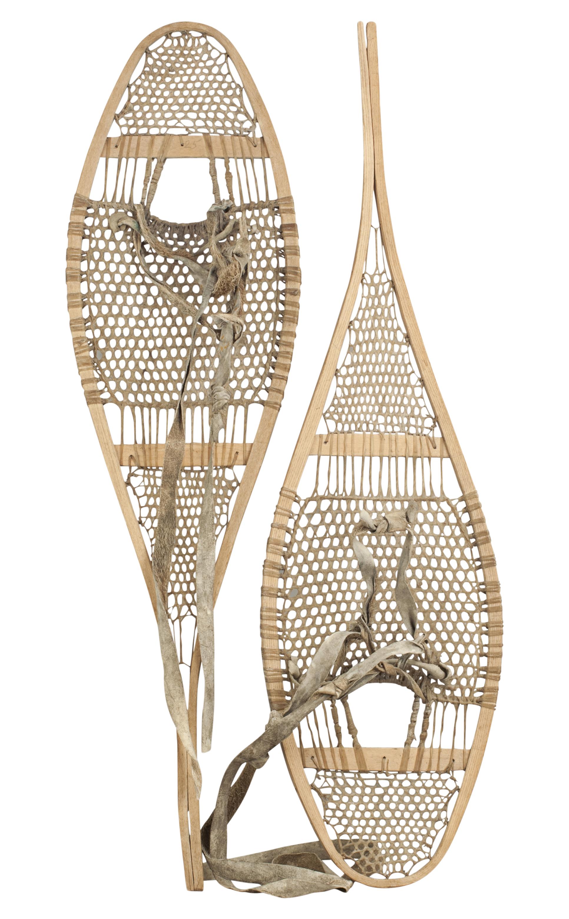An attractive and outstanding pair of snow shoes constructed from bent hickory frames with stretchers and interlaced gut supports. The snow shoes are in great original condition with reindeer skin boot ties.

Snowshoes were a common form of