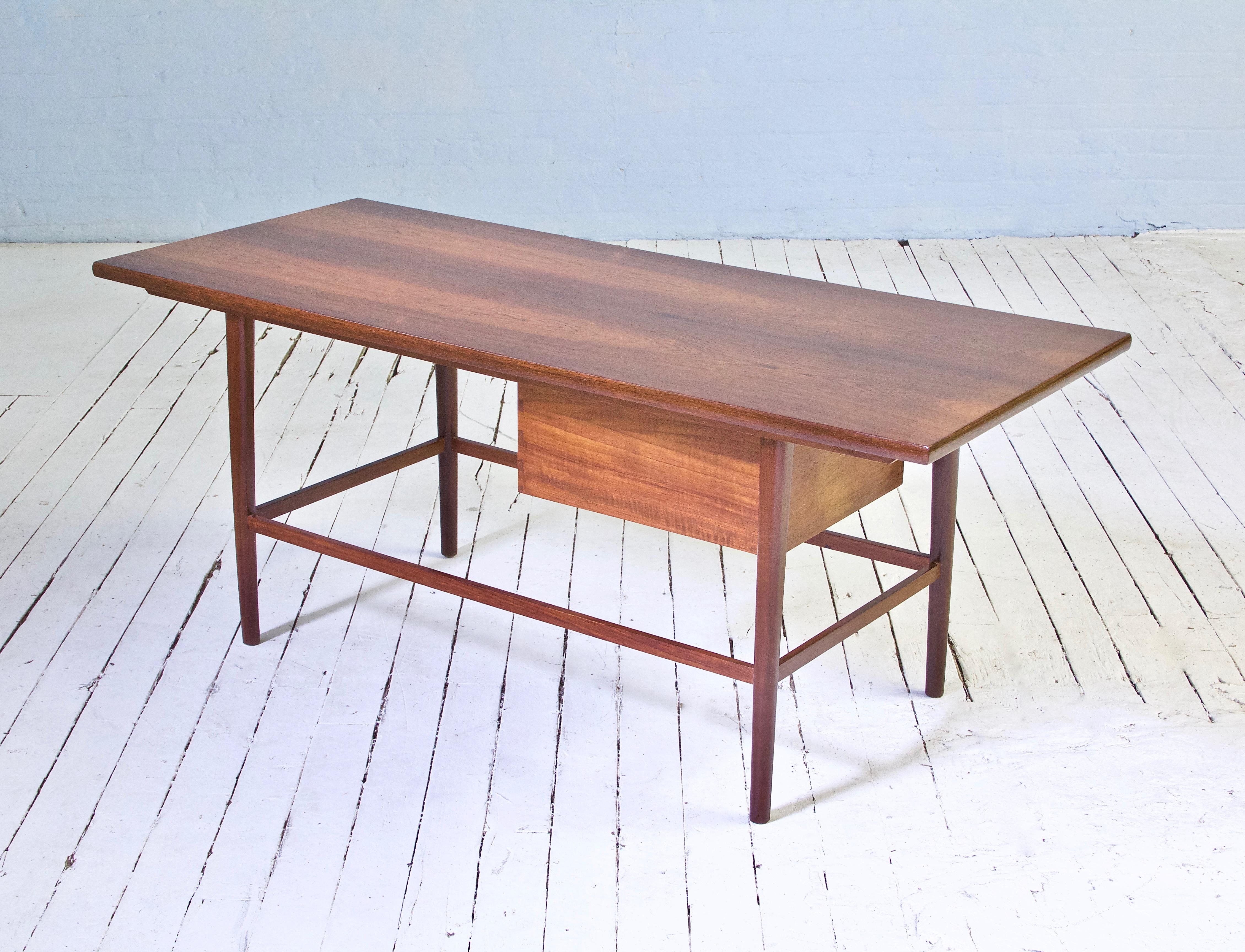 Attractive Norwegian modern cocktail table featuring a richly colored book-matched rosewood top supported by round tapered legs joined by rectangular stretchers. This unique table has a 