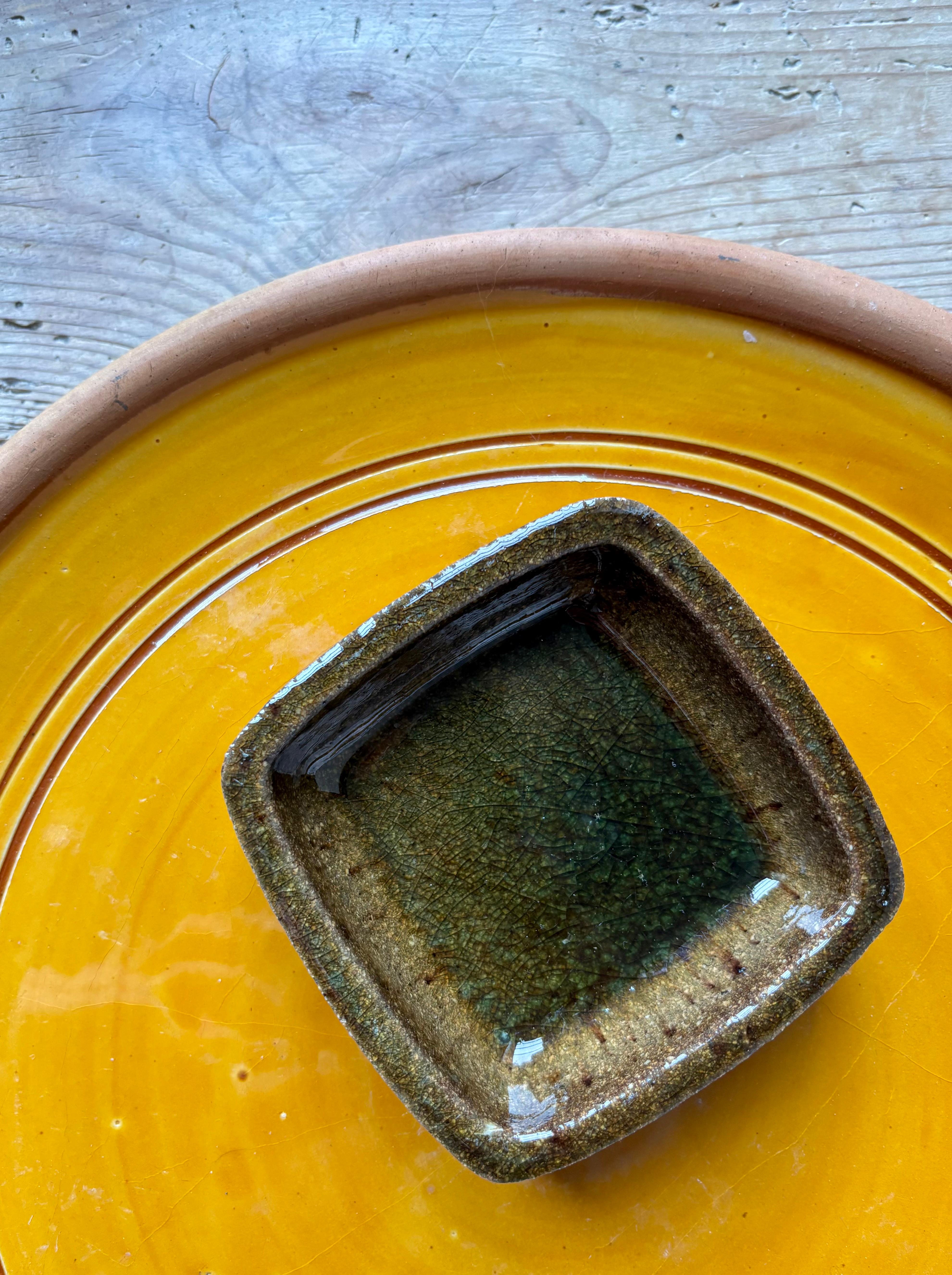 Vintage Norwegian rustic stoneware vide-poche bowl manufactured by Porsgrund Porselænsfabrik in 1969. Shiny earth colored brown, green and ochre crackle glaze on the inside while the outside of the bowl is kept unglazed and raw. 
Stamped and dated