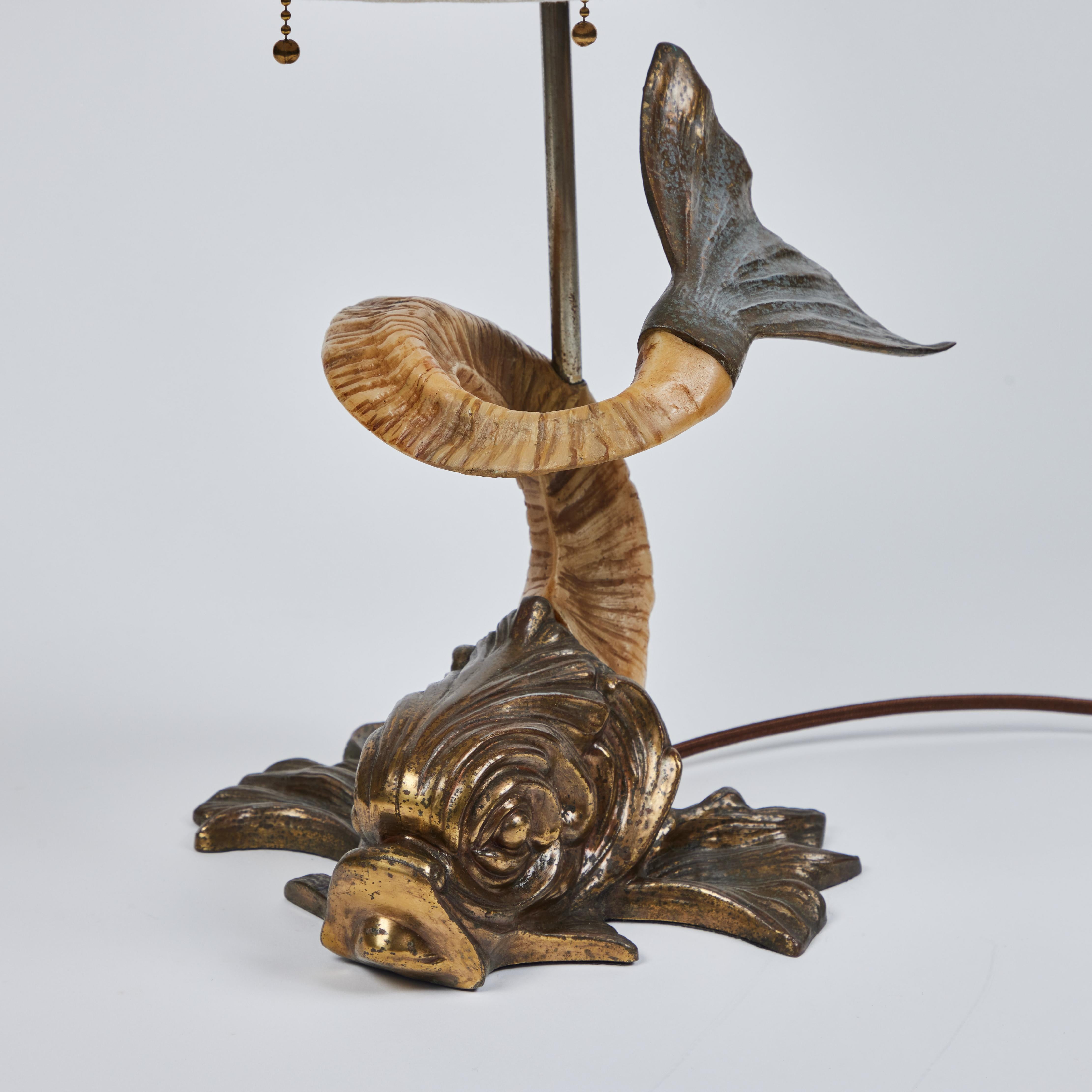 How fun is this Vintage Koi Fish Table Lamp? It represents a classic sculpted koi fish with a body made up of a curved carved resin ram's horn. The base (head), tail, lamp body and finial are metal with an antique brass finish. The lamp is topped
