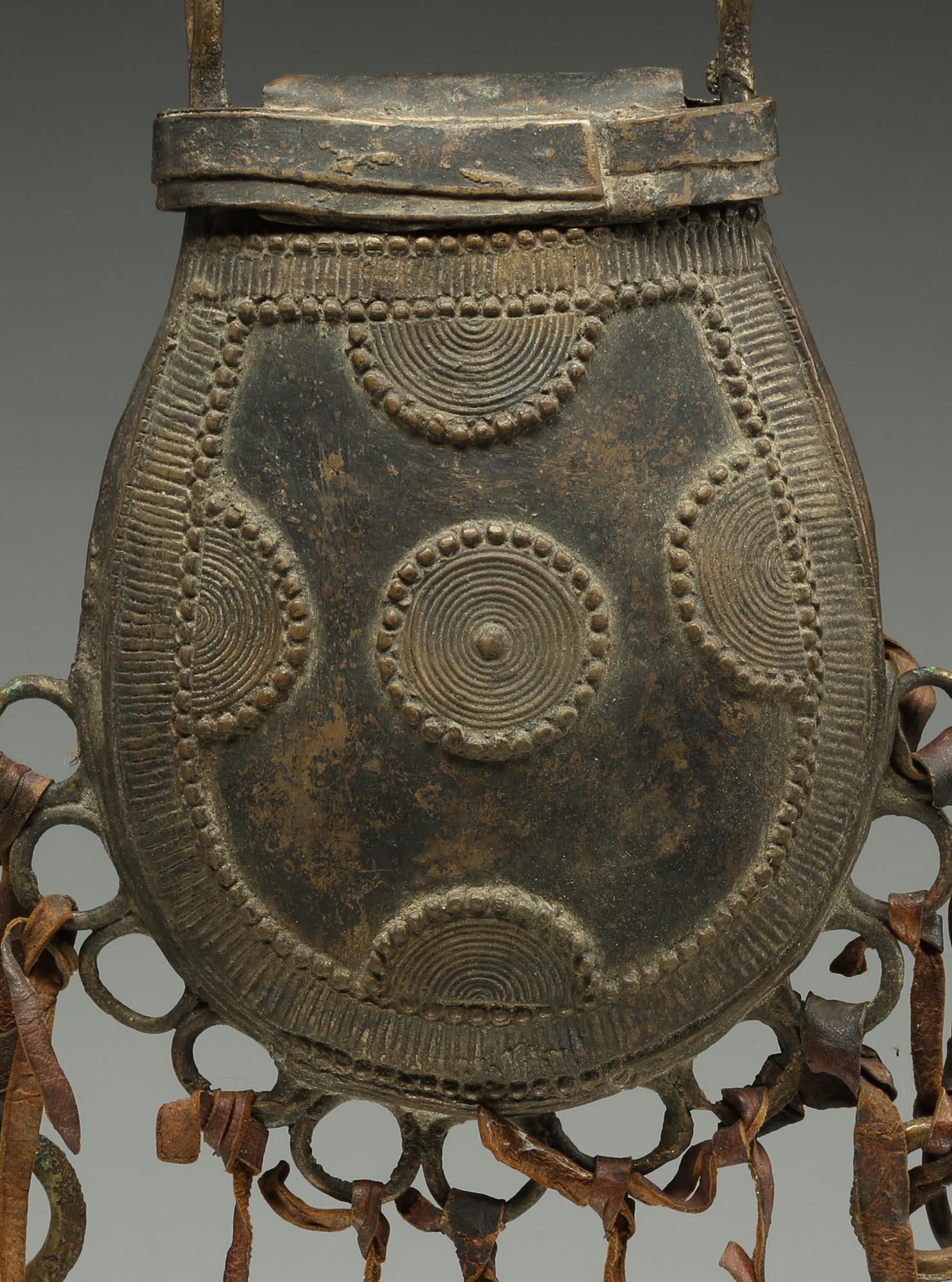 Vintage Nupe of Nigeria thinly cast hollow bronze purse or container, probably created by the lost wax process with attached bronze bells and rings. Hollow with fine overlaid designs. Dulled from age, rear shows some polish from use, early 20th