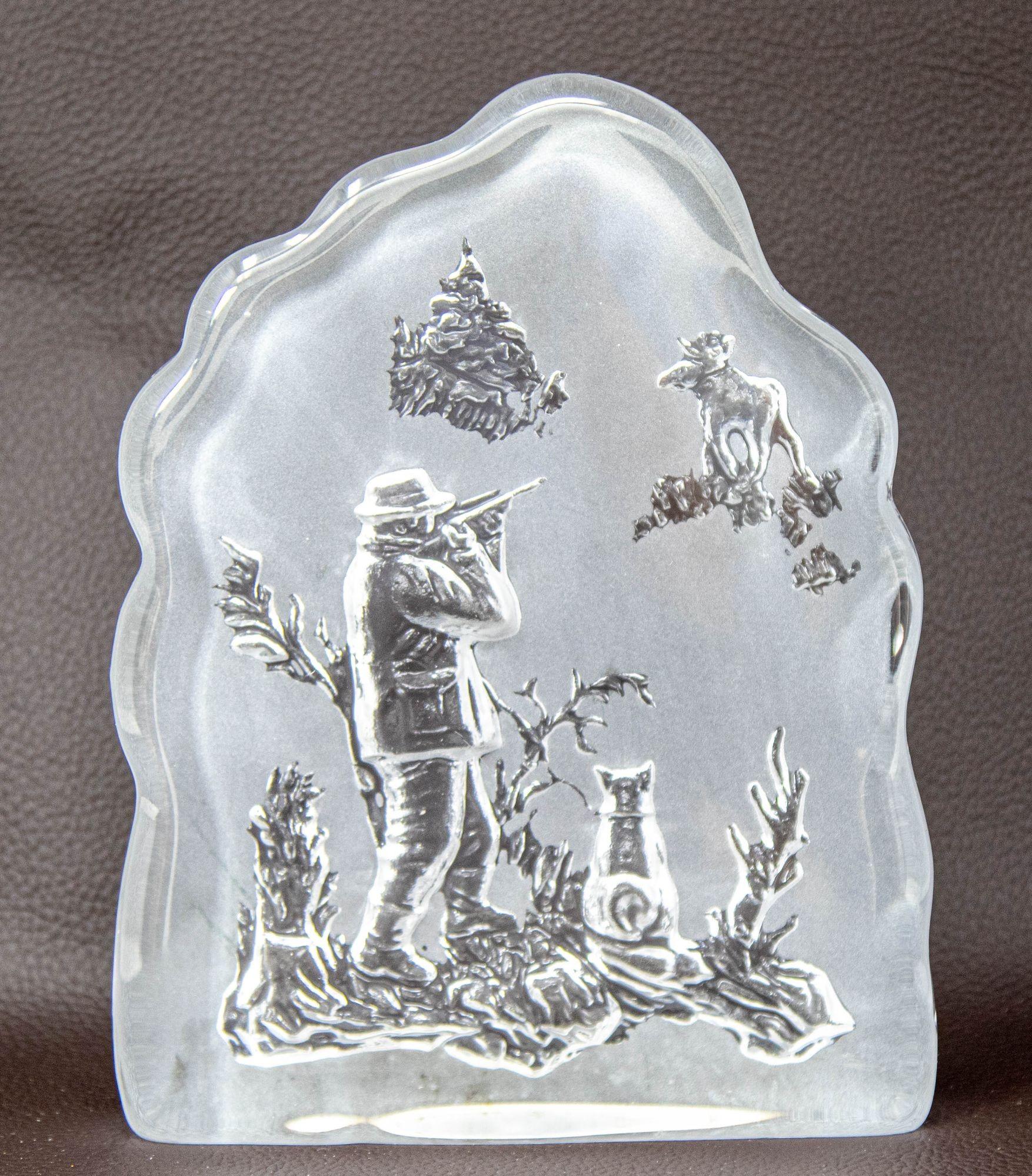 Vintage Bybro Sweden Hunter and Moose Large Crystal Art Glass Heavy Paperweight.
Fabriqué en Suède par Nybro, ce grand presse-papier vintage en verre représente un chasseur qui vise un élan au loin.
Le chasseur, qui se prépare à tirer, a son chien