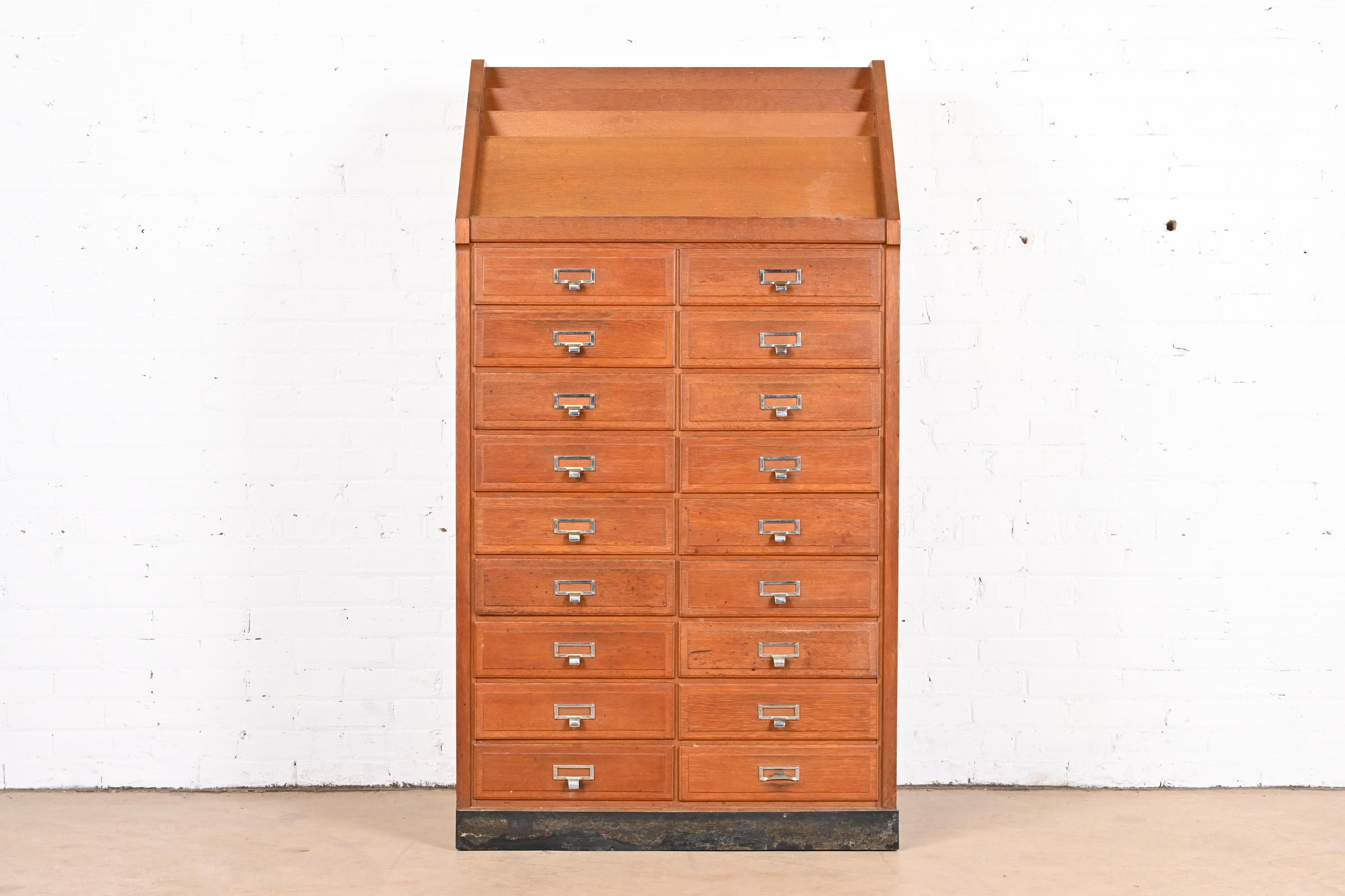 A fantastic oak 18-drawer library card catalog or file cabinet with book or magazine rack on top

USA, Mid-20th Century

Oak, with original metal hardware.

Measures: 33.25