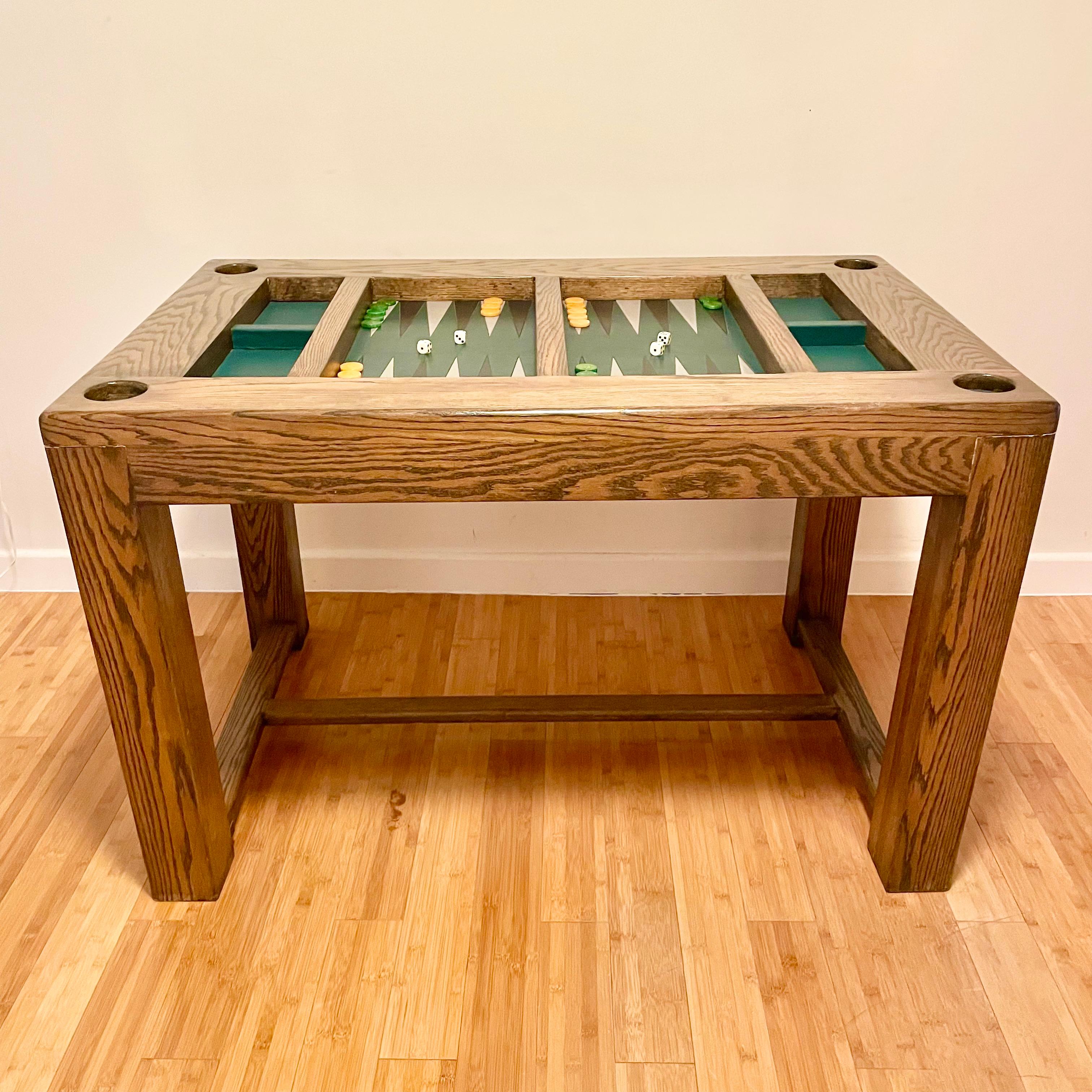 Table de backgammon classique en chêne et cuir. La surface de jeu est un cuir vert riche avec des triangles de cuir noirs et blancs alternés. Un jeu de couleurs et une présence étonnants. Il est également livré avec des gobelets en cuir pour les