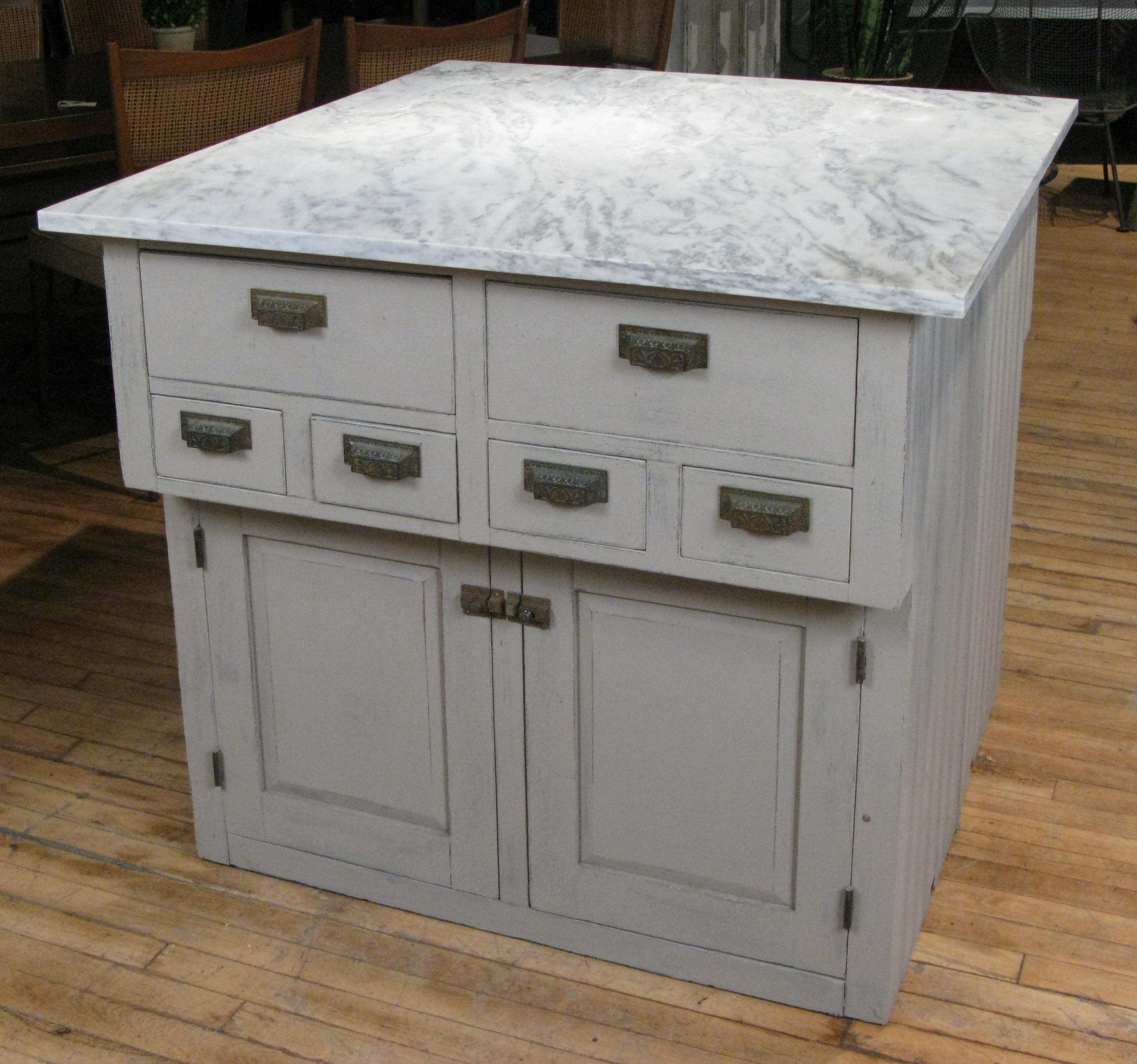A very handsome vintage oak kitchen storage island, with an antique marble top. the matching pair of cupboards (placed back to back in the pictures) each have the same configuration of six drawers above and then stepped slightly back below there are