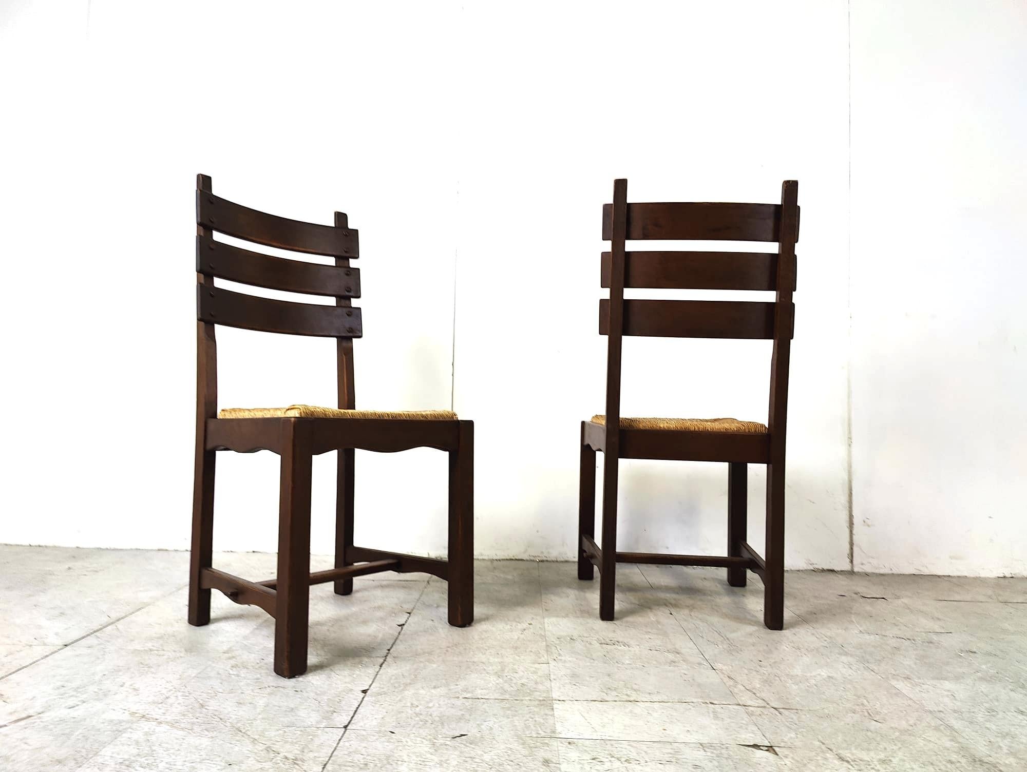 Chaises de salle à manger vintage en chêne robuste et osier de style brutaliste.

Châssis en chêne robuste et durable avec des sièges en osier épais.

Les dossiers hauts sont un élément clé du design de ces chaises.

Années 1960 - Belgique

Bon état