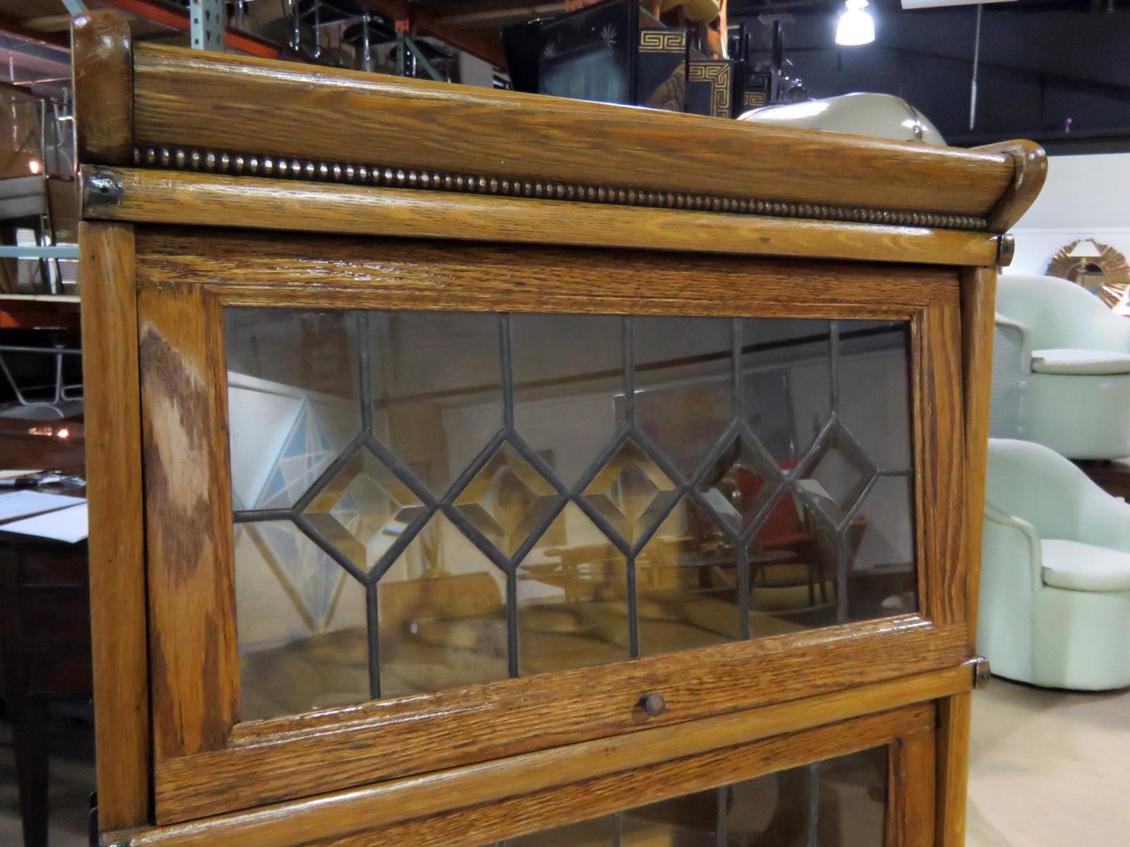 Vintage oak 5 section barrister bookcase, attributed to Macey, with leaded glass and a drawer at the bottom.