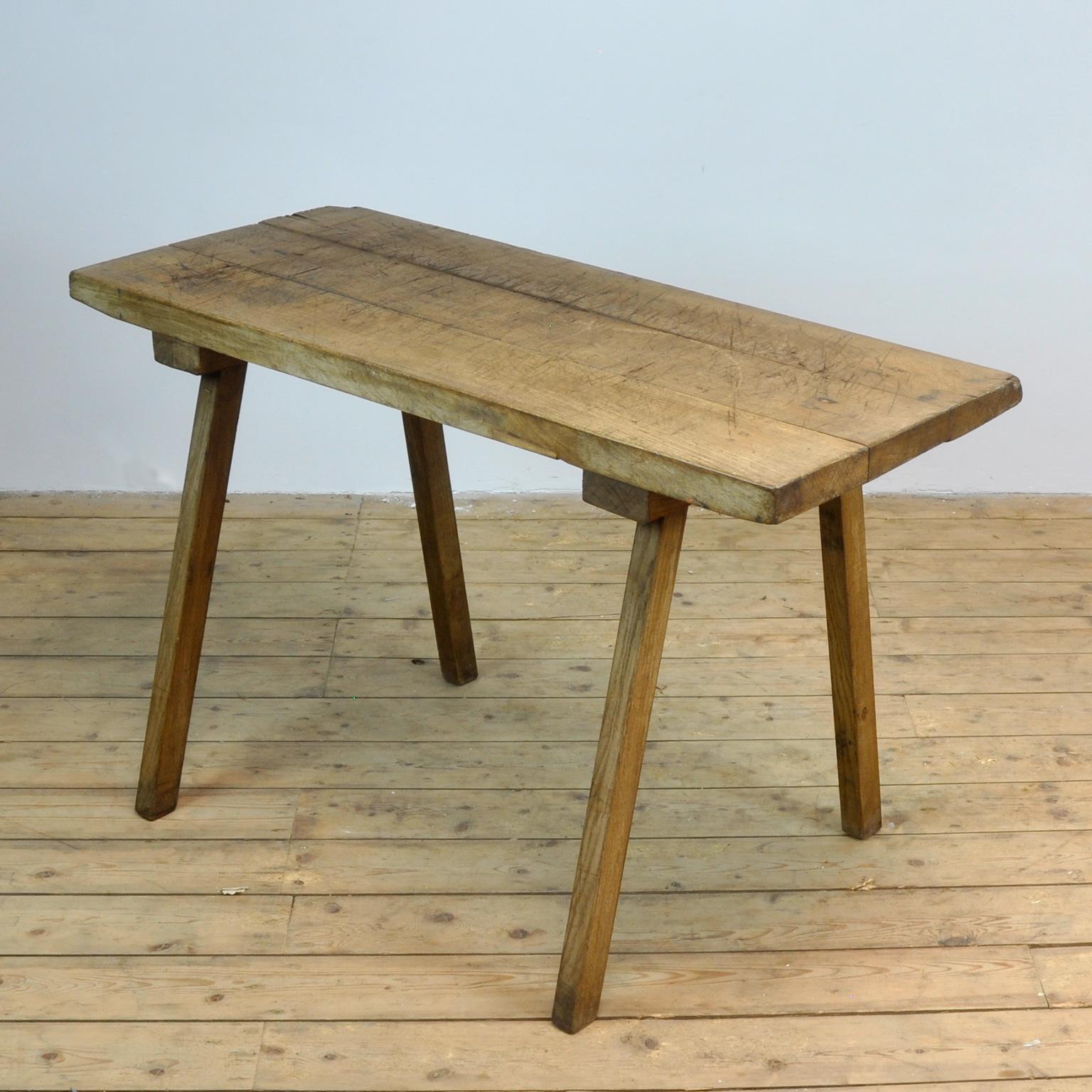 This oak butcher's farm table was produced in Hungary circa 1930s. With a nice distressed oak top of 5.5 cm thick. This piece features the original legs and has been wax-finished.
