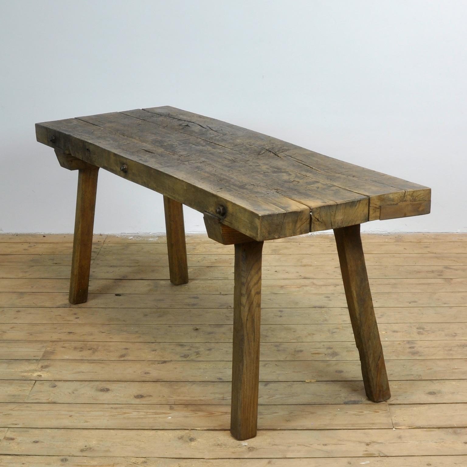 This oak butcher's farm table was produced in Hungary circa 1930s. With a nice distressed oak top of 7 cm thick. This piece features the original legs and has been wax-finished. Treated for woodworm.