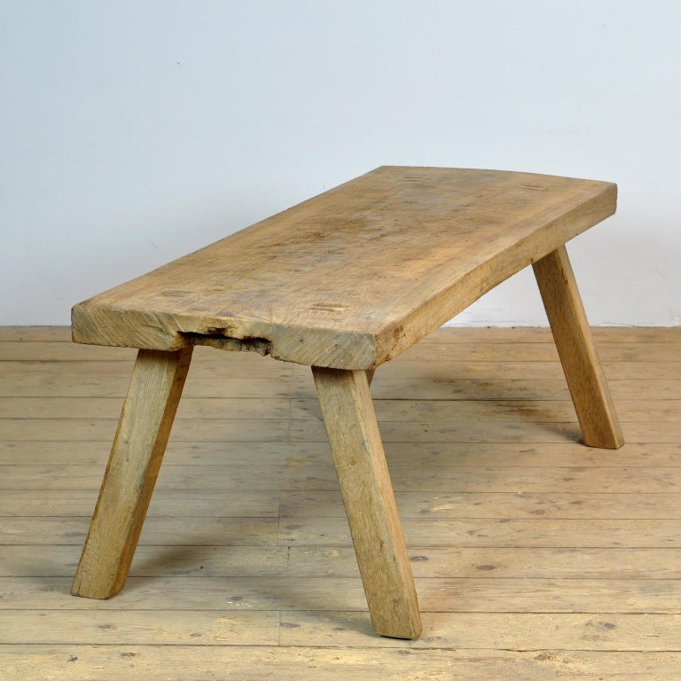 This oak butcher's farm table was produced in Hungary around the 1930s. With an oak top of 6 cm thick. The legs are shortened to the ideal height for a coffee table or bench. When the table was made, the maker made markings in the legs and table for