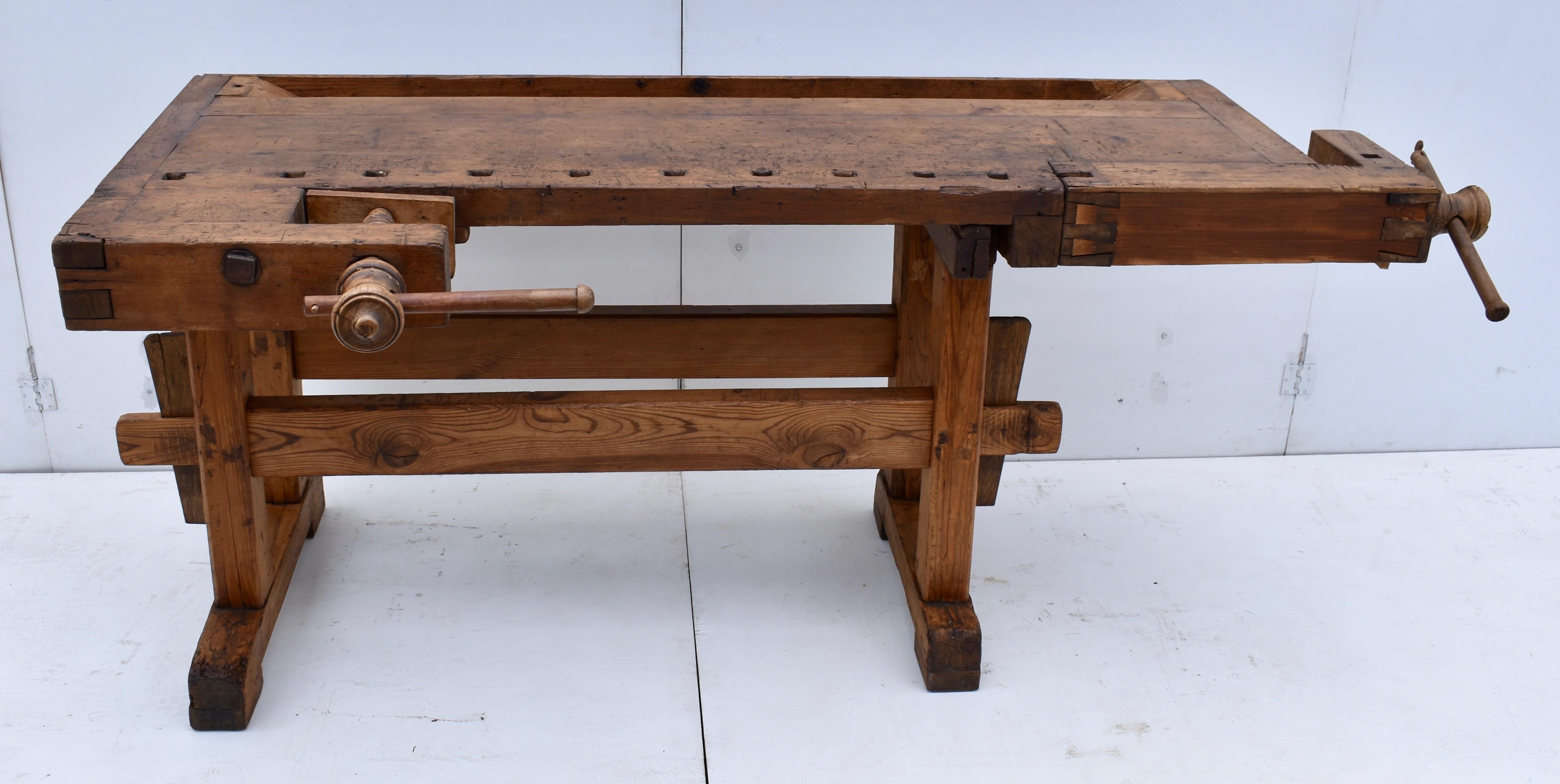 This joiner’s work bench is well-used but not too chopped up. It is built as solid as a rock. The trestle-style base is made largely of oak. The uprights are 3” square, hand-cut and chamfered on the corners, through-tenoned and pegged top and bottom