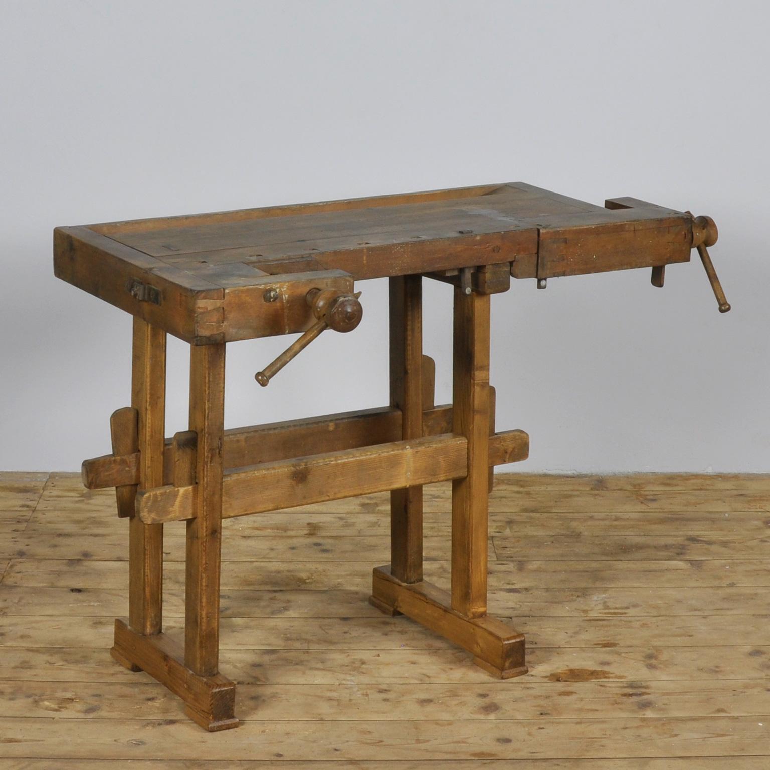 This vintage Hungarian carpenter’s workbench features two vices and a recessed tray where the carpenter would lay his tools. It was manufactured, circa 1935. Made of oak.