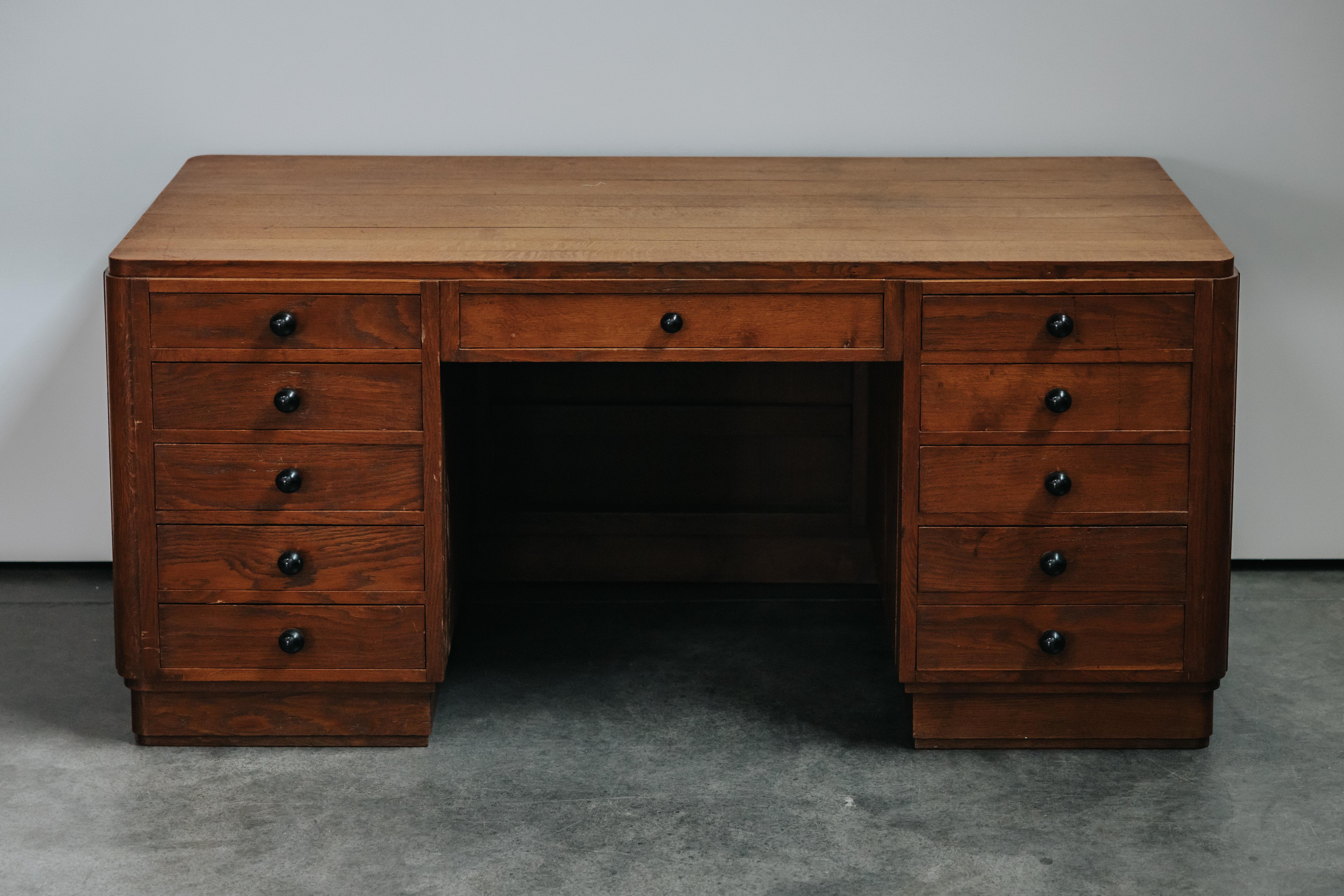 Bureau vintage en chêne de France, CIRCA 1960.  Construction en chêne avec onze tiroirs.  Légère usure et utilisation.