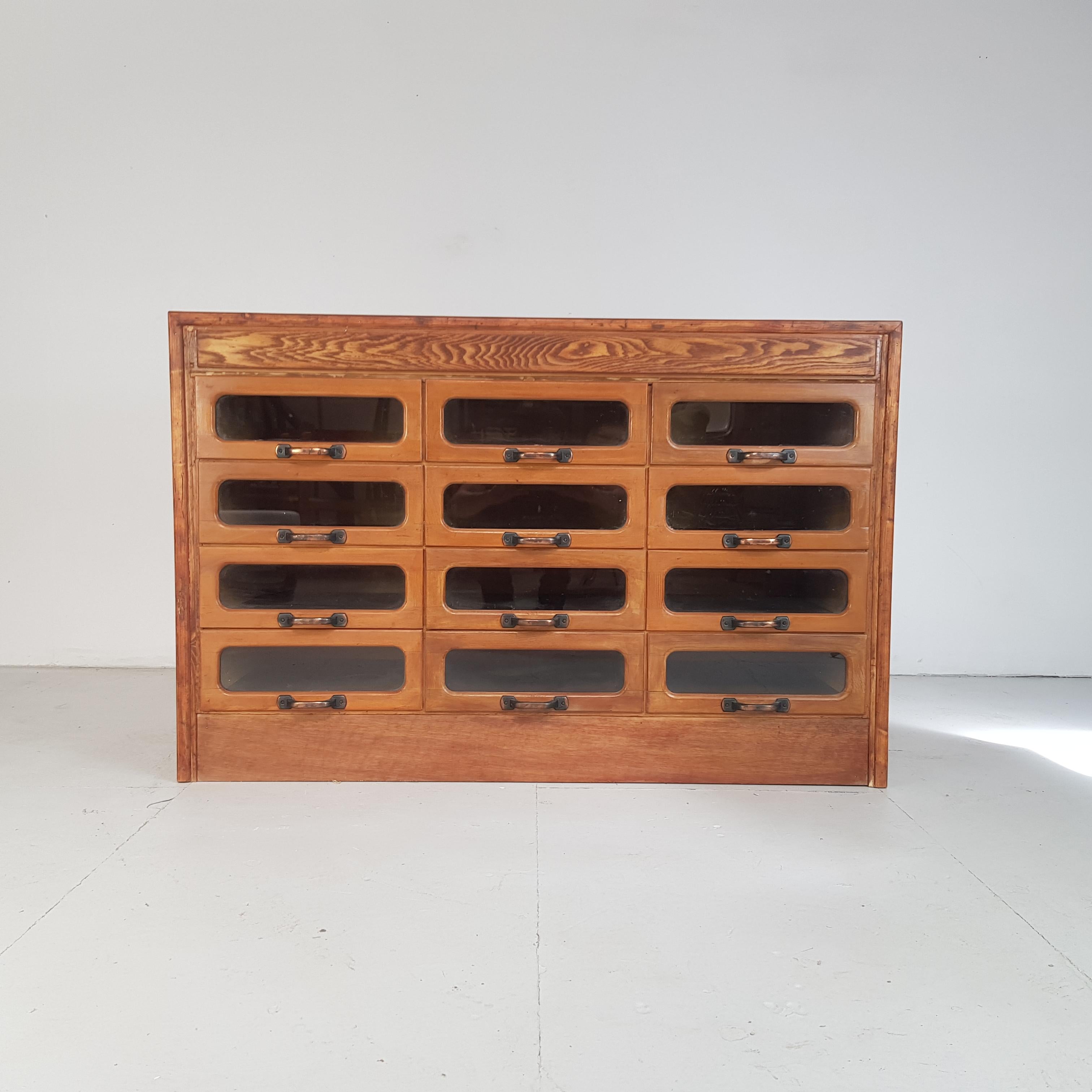 Lovely 12-drawer haberdashery shop cabinet from the first half of the last century. 

It has 12-glass fronted drawers, all with original metal D handles.

Approximate dimensions:

Width 125cm

Height 81cm

Depth 53cm.

Drawers: 36cm W x