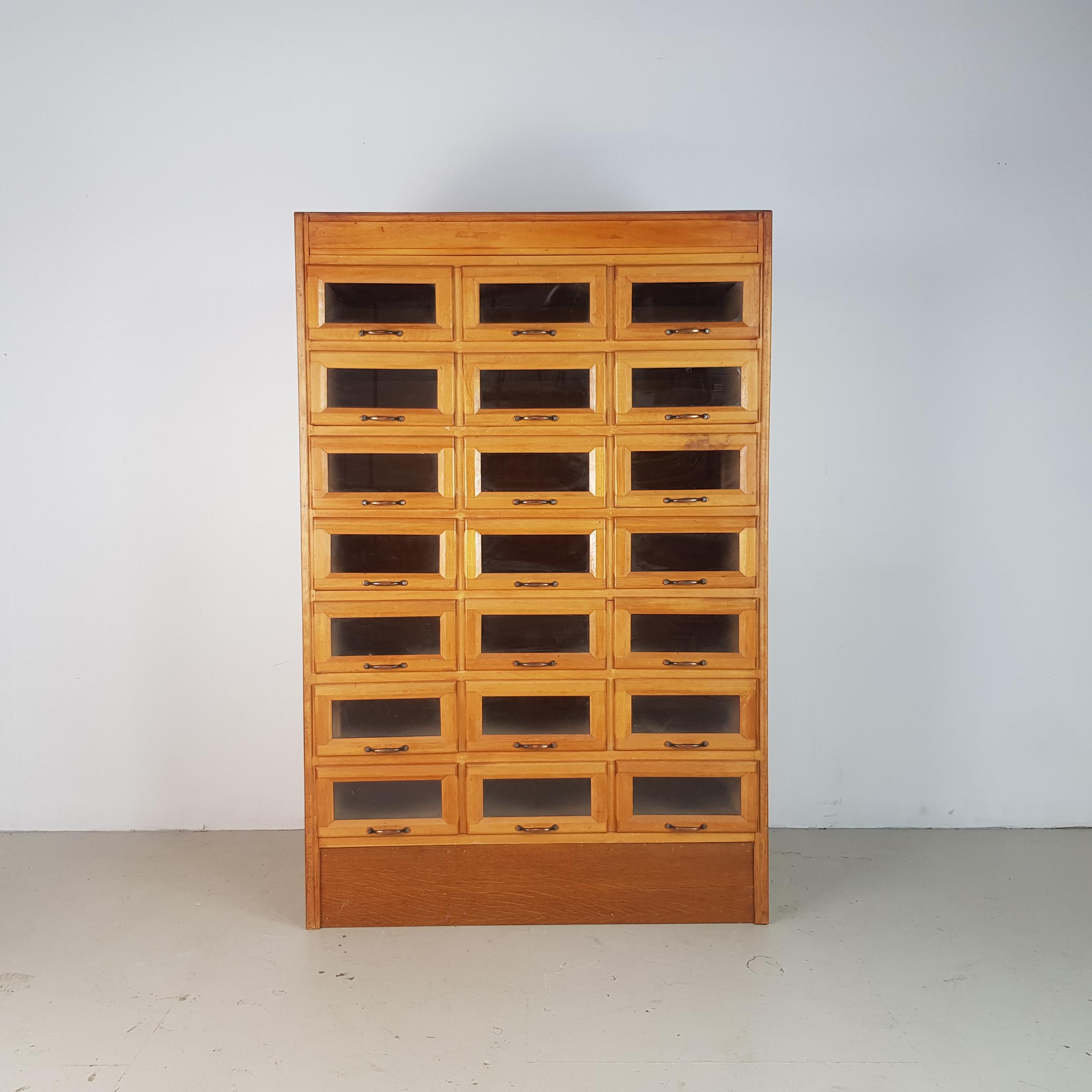 Lovely 21 drawer haberdashery shop cabinet from the first half of the last century. 

It has 21 glass fronted drawers, all with original metal D handles.

Approximate dimensions:

Width: 92cm

Height:141cm

Depth: 52cm.

Drawers: 25cm W