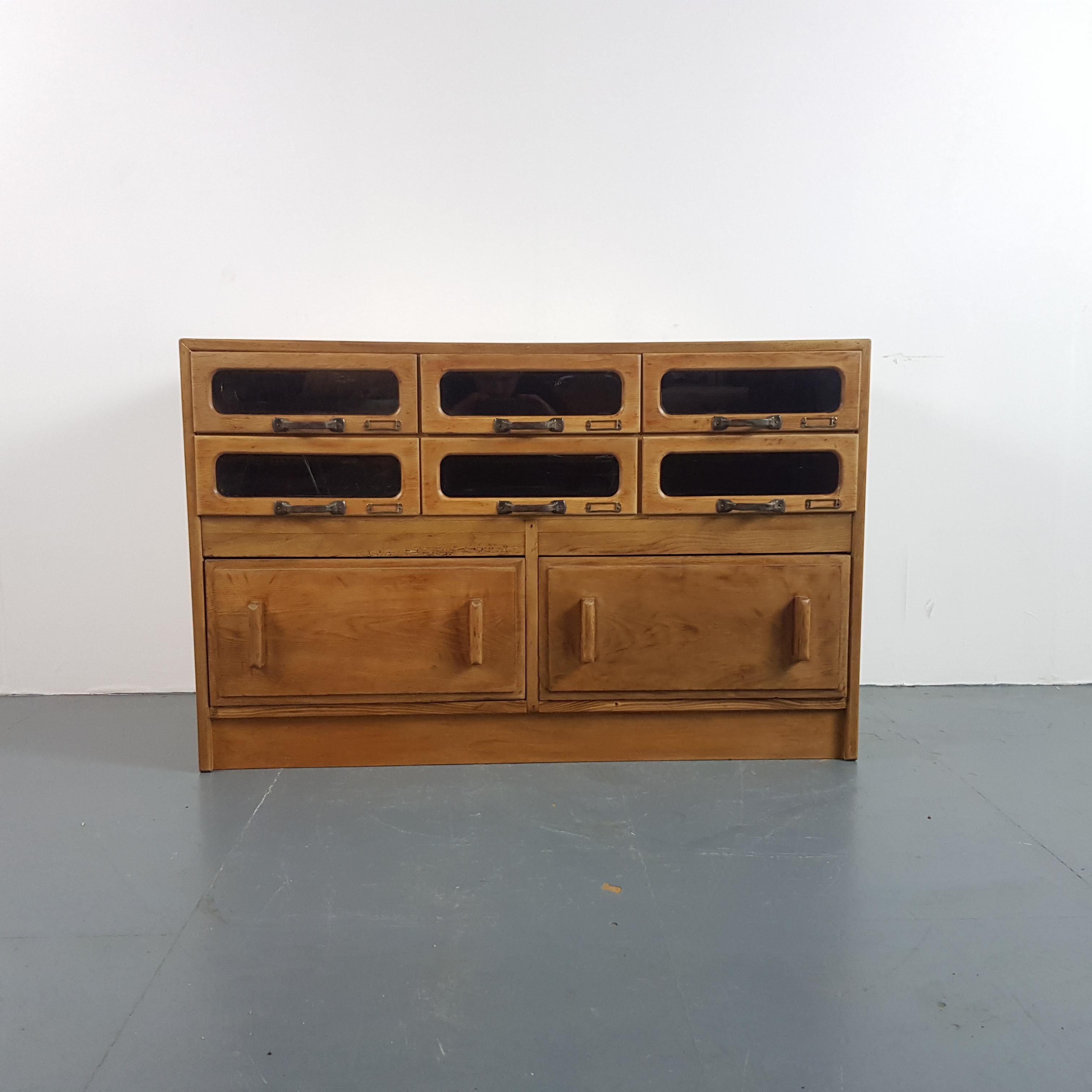 Lovely 8 drawer haberdashery shop cabinet from the first half of the last century. 

It has 6 glass fronted drawers, all with original metal D handles.

Approximate dimensions:

Width: 119cm

Height: 76cm

Depth: 52cm

Drawers: 36cm W x