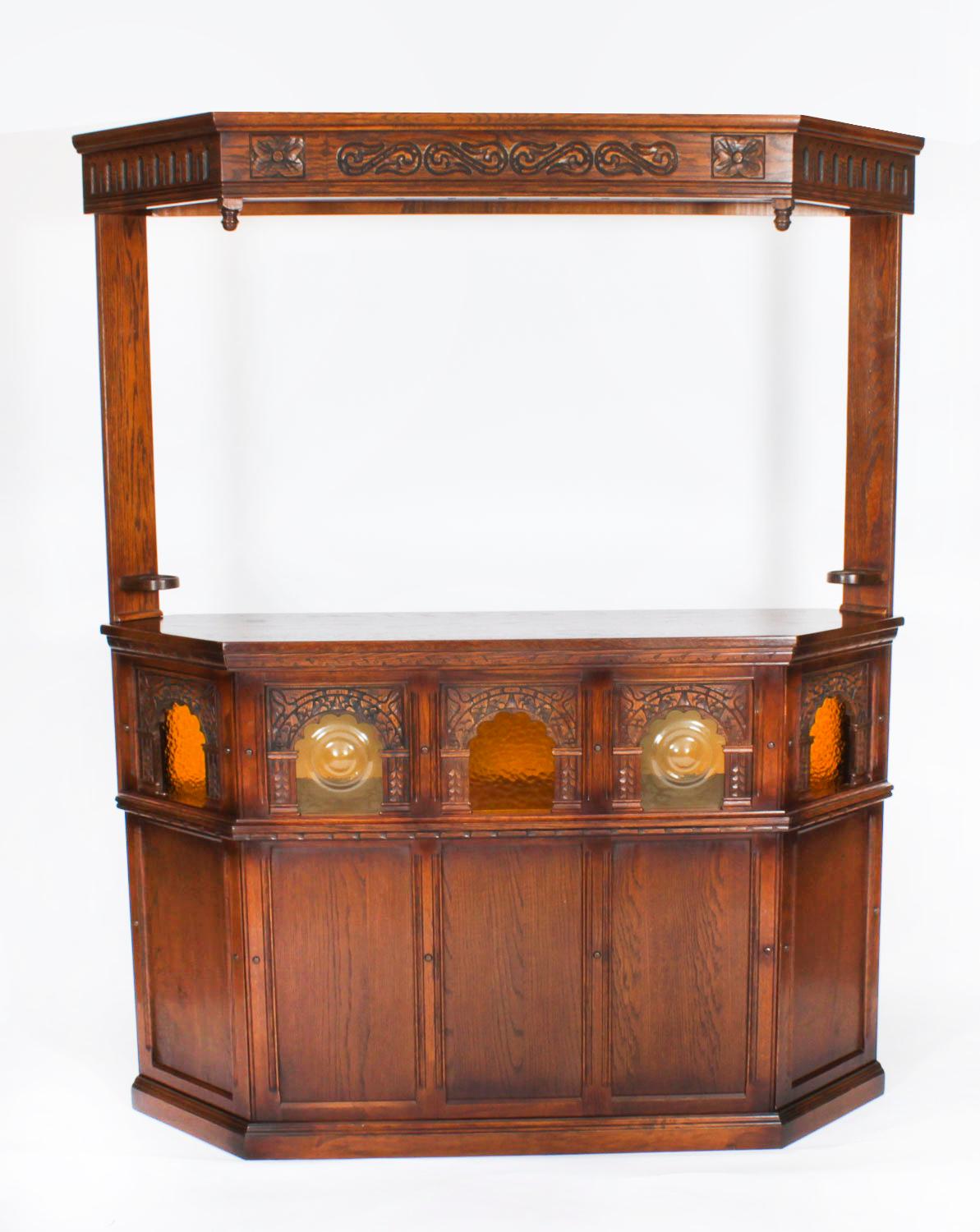 Il s'agit d'un fantastique bar vintage en chêne de style néo-jacobin avec auvent, complet avec verres et set de bar en métal argenté avec accessoires de bar, datant du milieu du 20e siècle.

Le bar en chêne de belle forme est doté d'un auvent pour