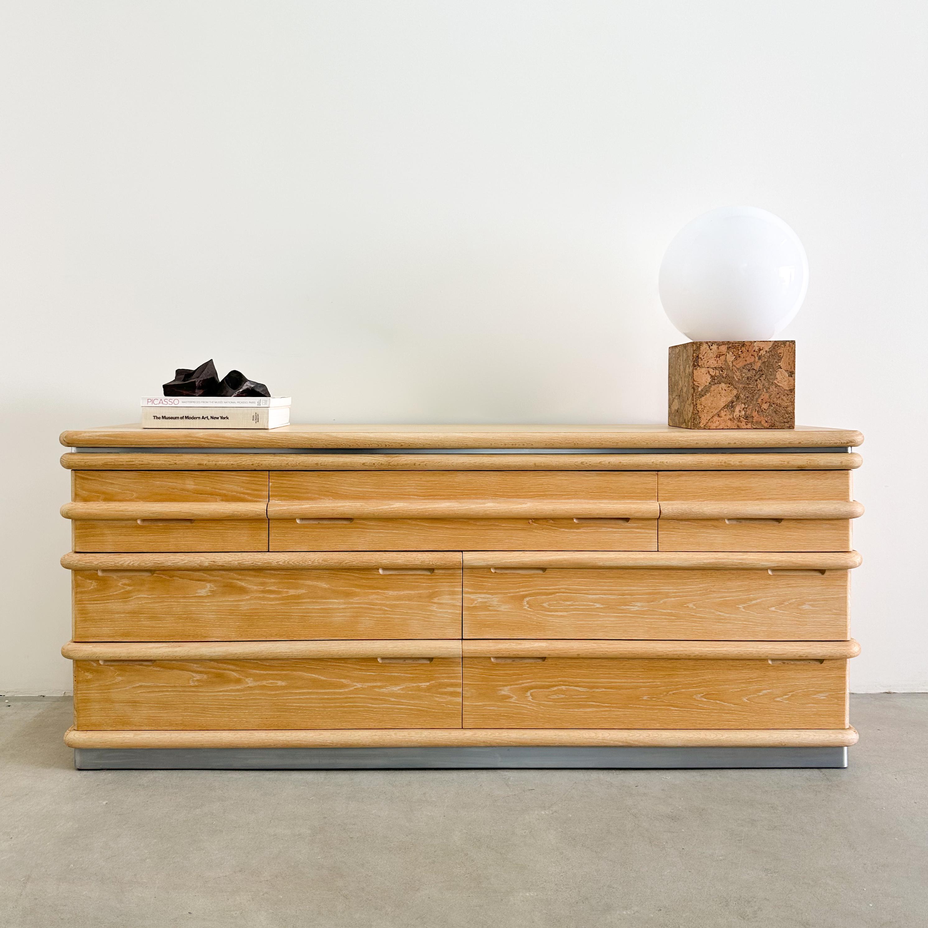 Cómoda vintage Jay Spectre para Century Furniture de los años 80.

Esta cómoda tiene cajones de deslizamiento suave con un interior limpio. El embellecedor está hecho de metal cepillado, complementando la construcción de roble macizo, lo que lo
