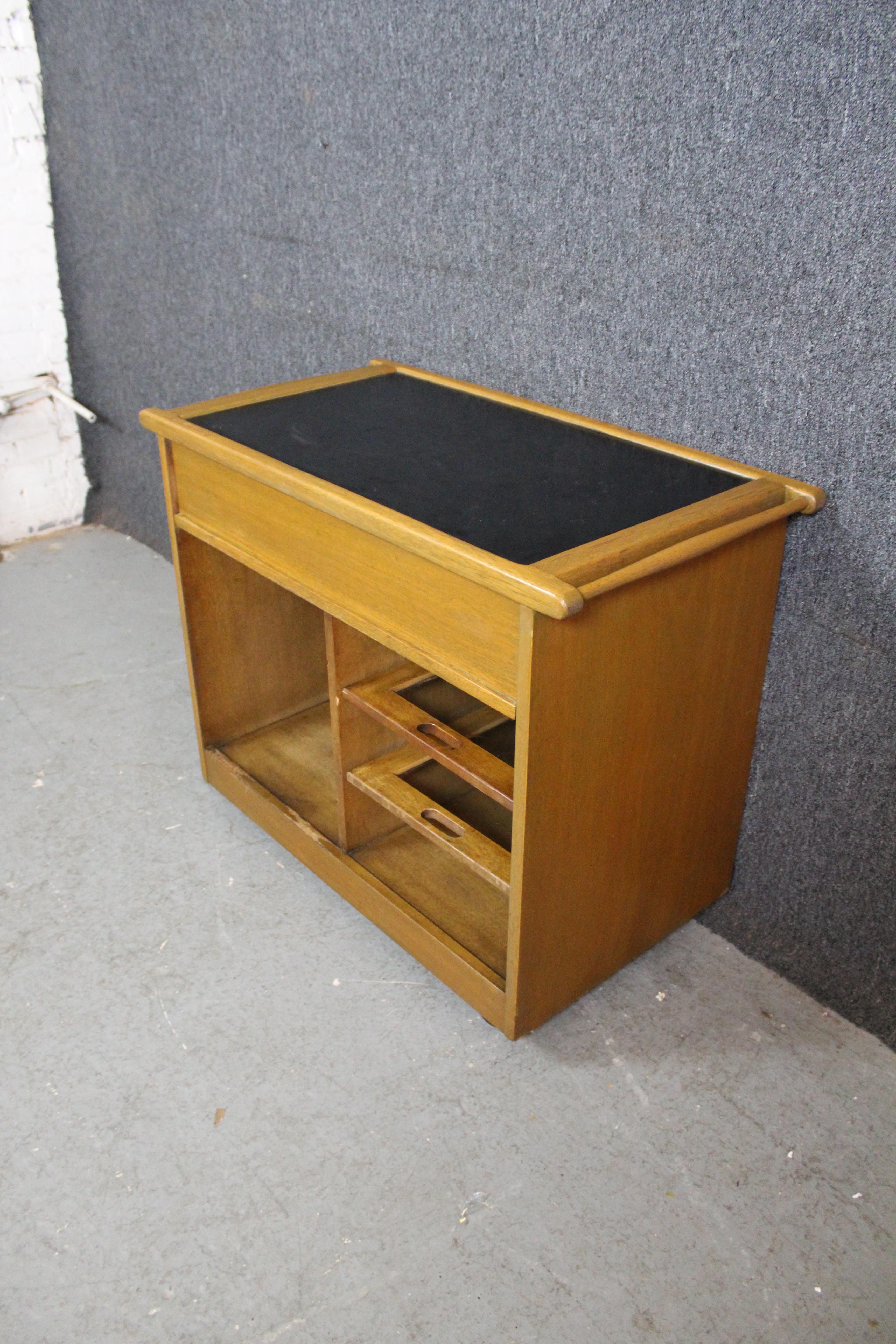 Give your home decor a vintage spin with this mid-century oak cart by Camden, New Jersey's J.B. Van Sciver Furniture Co. This free-wheeling design features a convenient pull-out drawer for storing flatware, napkins, or more; while the bottom