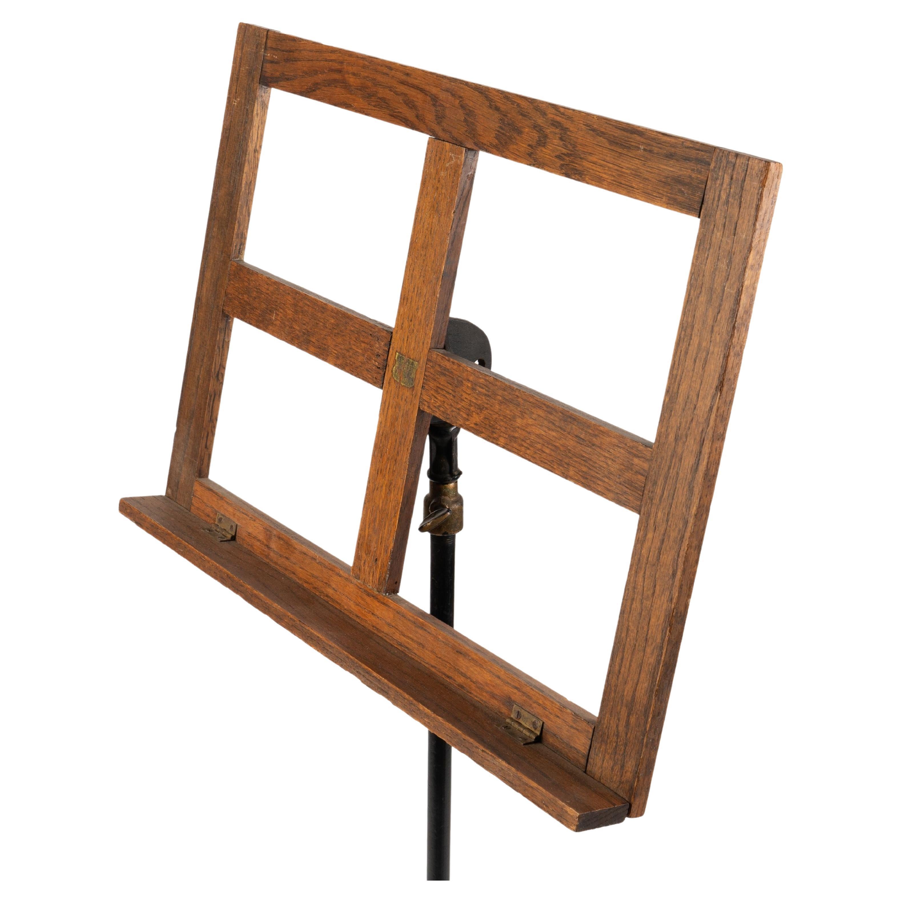 Oak music stand on adjustable iron rod with cast iron tripod base.
American, 19th century.

Dimensions: 20” W x 2” D x 42-1/2”–61” H.