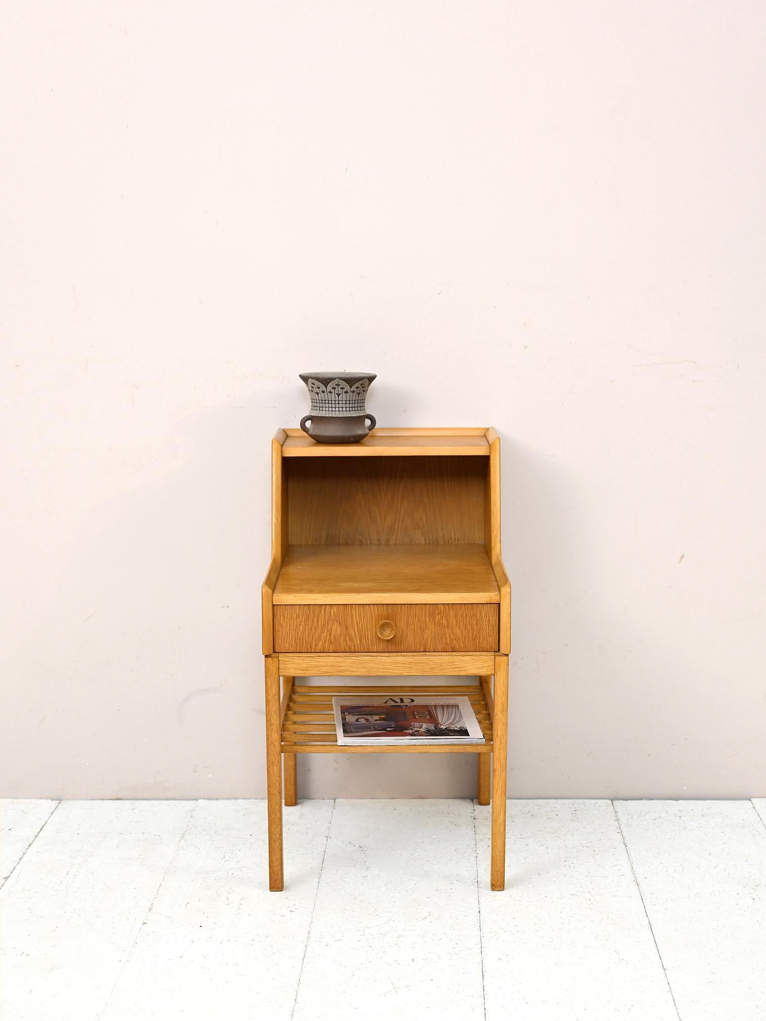 Scandinavian 1960s nightstand with double shelf.

A piece do design of Nordic manufacture with modern and functional lines.
It is distinguished by its original shape given by the presence of a double shelf. 
There is also a magazine shelf and a