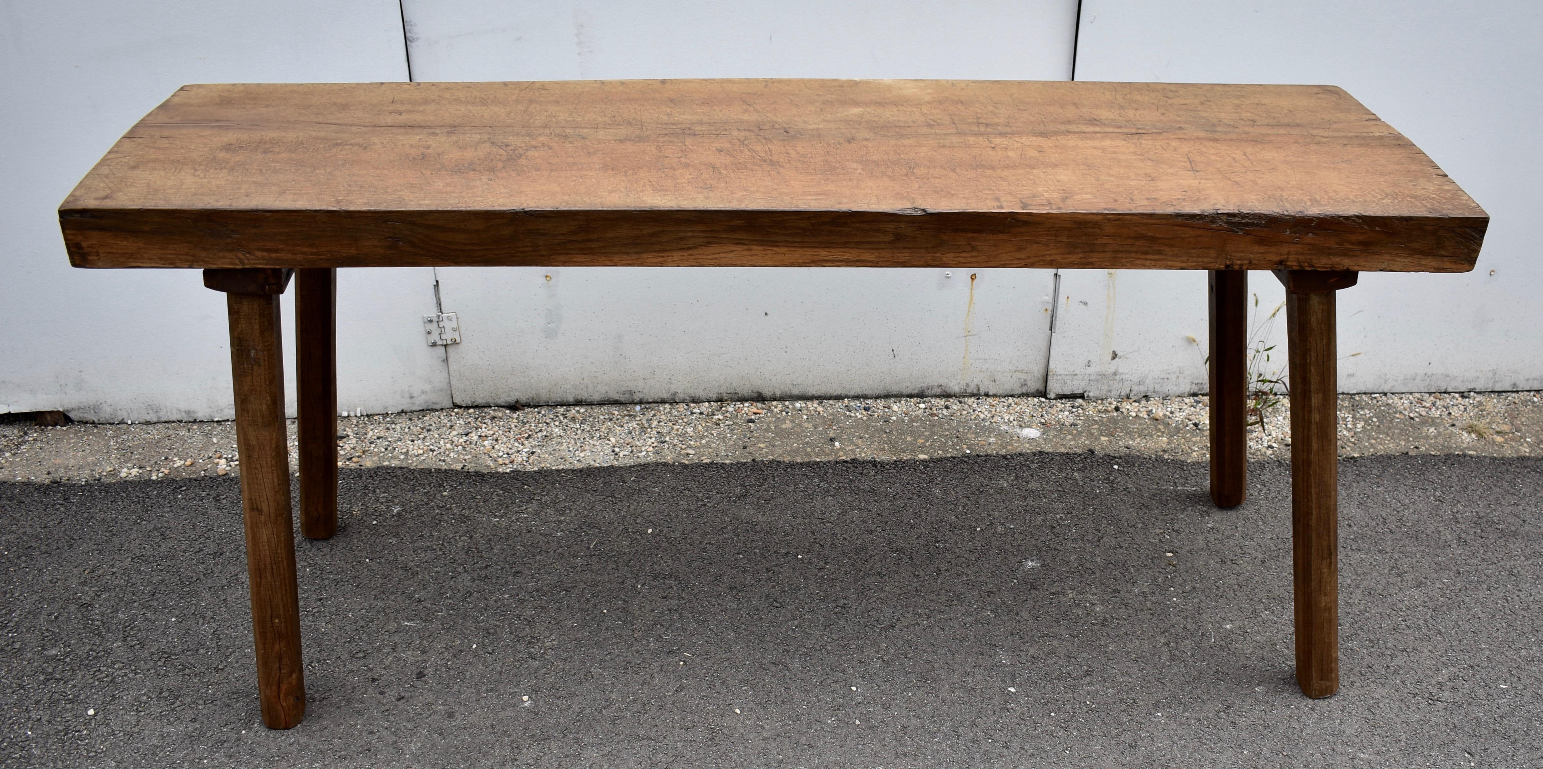 This is an extremely heavy Pig Bench Table.  The top is a single slab of oak nearly six feet long and over three inches thick.  To resist splitting, both ends have heavy duty iron staples hammered deep into the end grain.  The big square legs are