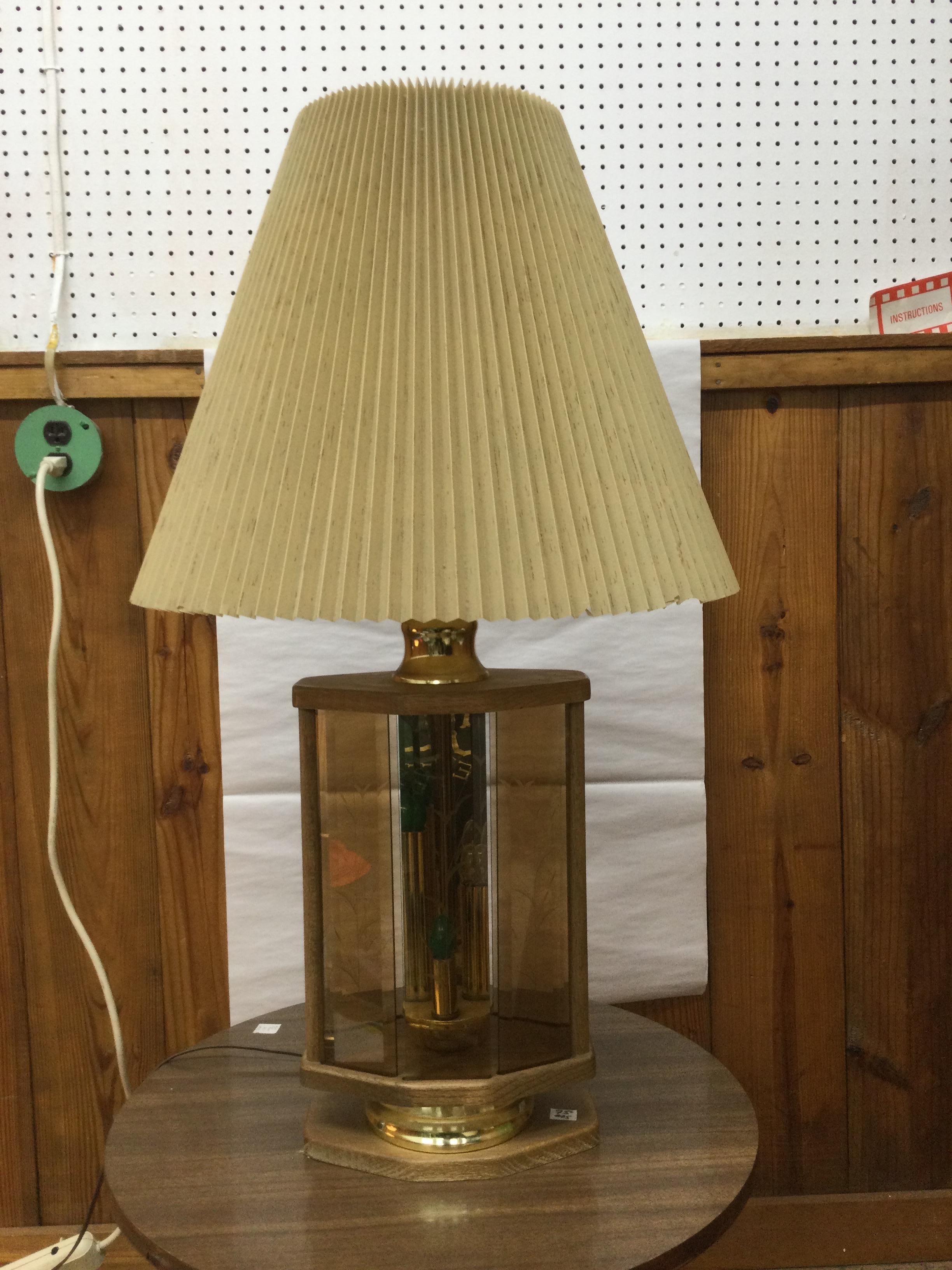 This vintage table lamp features solid oak construction, brass accents, etched beveled glass plates, switch controlling interior lights and main bulb, original wiring and pleated shade.   Dimensions in listing are without shade.  Dimension with