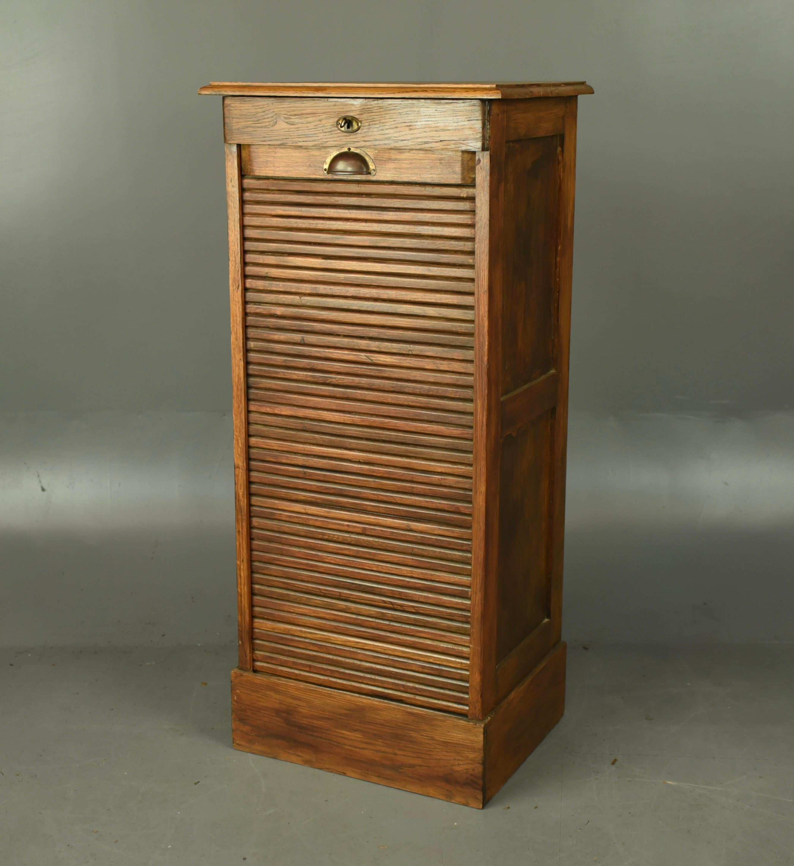 Antiker Aktenschrank aus Eichenholz mit Tambourfront um 1920 .
Der Schrank ist in einem guten gebrauchten Zustand, er hat 9 ausziehbare Fächer, der Tambour funktioniert wie er soll und kommt komplett mit einem funktionierenden Schloss und