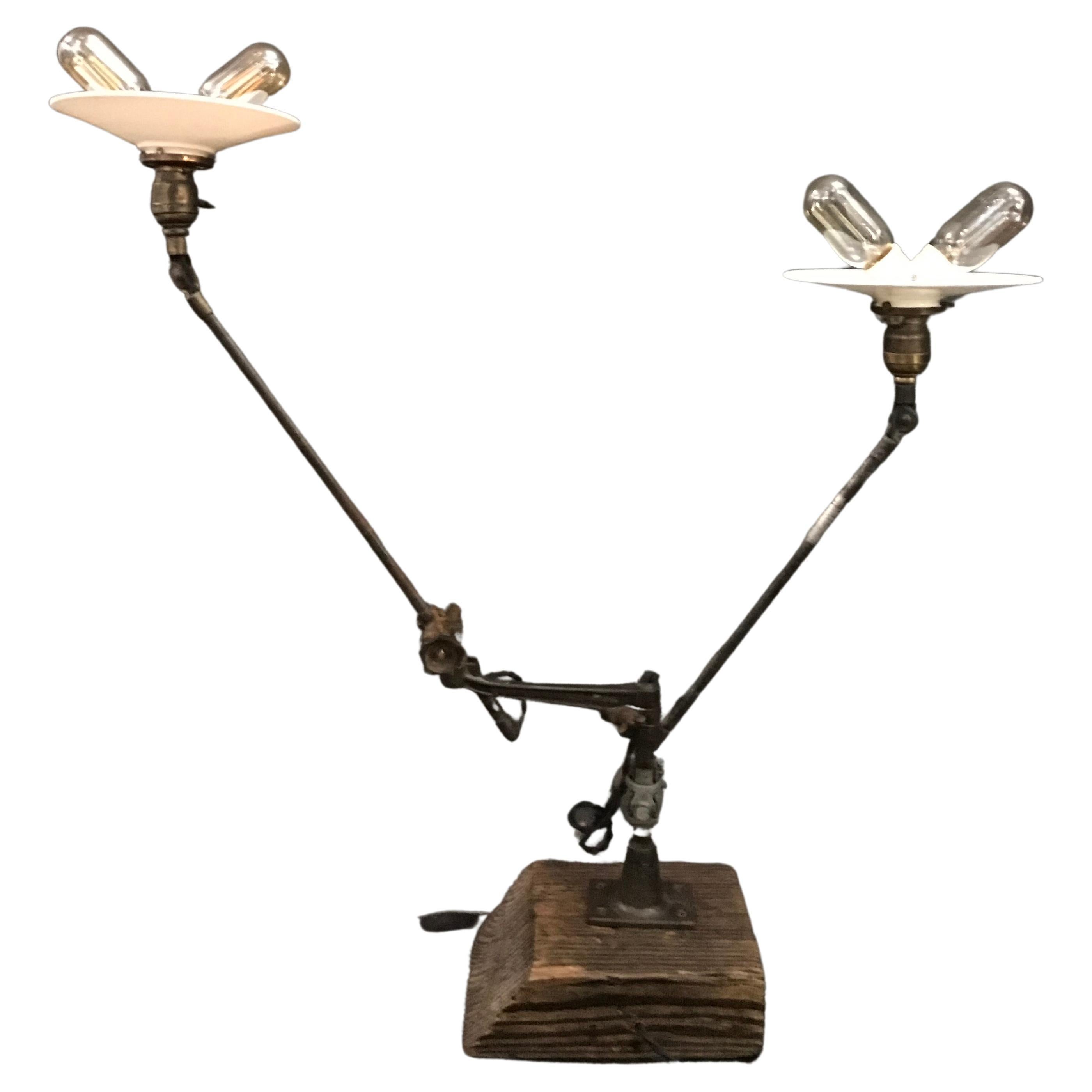 A two arm O.C. White table mount task lamp set on a reclaimed piece of French mantle wood. In vintage original unrestored patina, and freshly rewired with antique black cloth wire, featuring all original of period parts including two 8.5” round