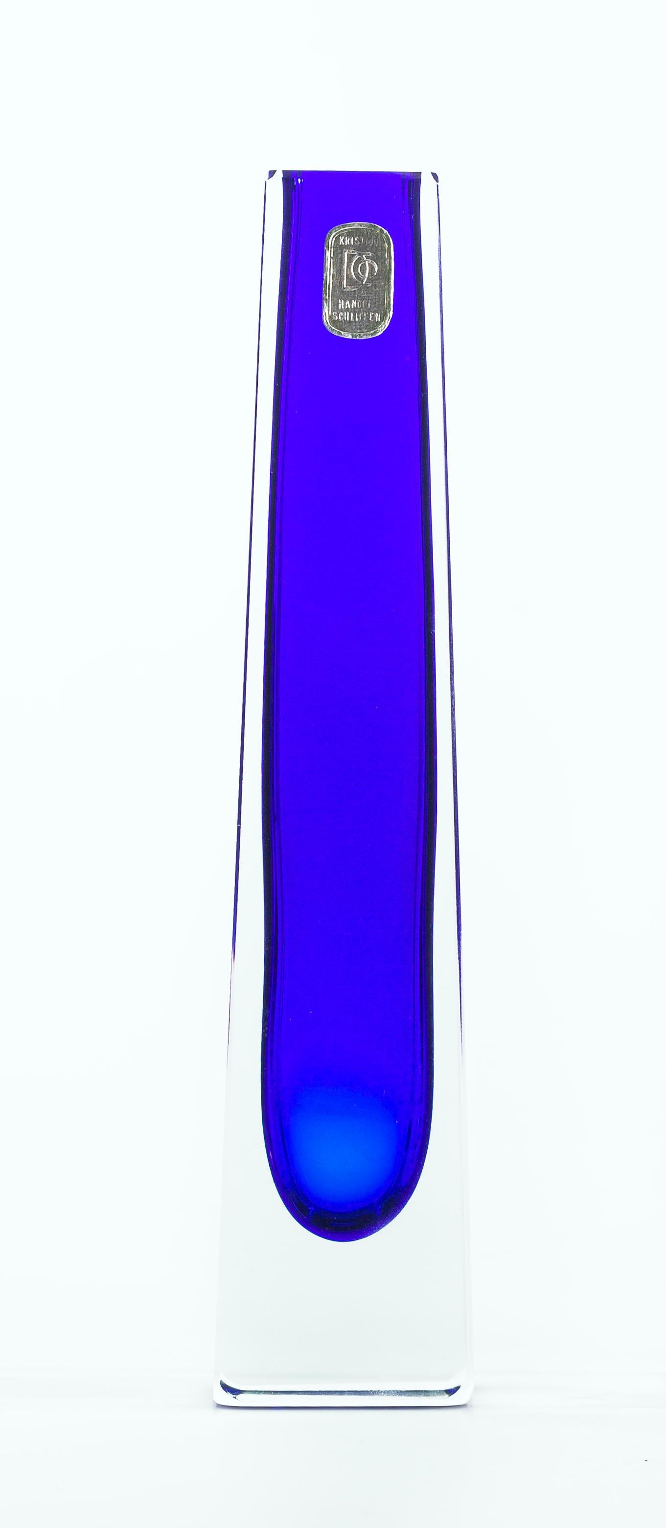 This Ocean blue vase is an original glass vase: a tall, slender pyramid-shaped jar with a rectangular base.
The ultramarine color stands out from the transparent glass shirt. The manufacturer's label is on the top edge.
Excellent conditions.