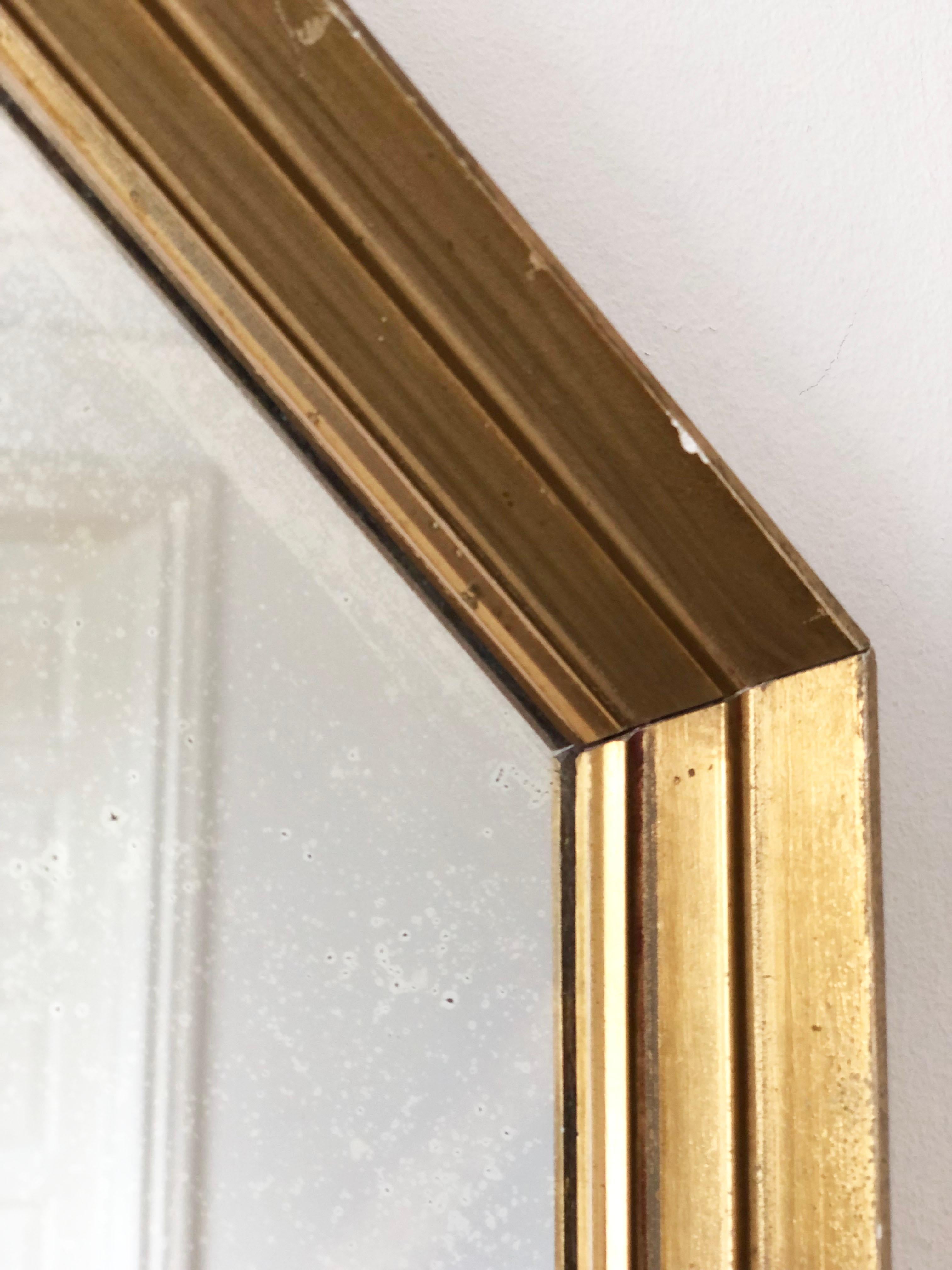 Eleganter achteckiger Spiegel im Vintage-Stil aus Belgien mit einem Rahmen aus vergoldetem Holz in zarter Goldoptik. Das geometrische Design verleiht ihm einen raffinierten und zugleich modernen Touch, während die subtile Tiefe des Rahmens ihm